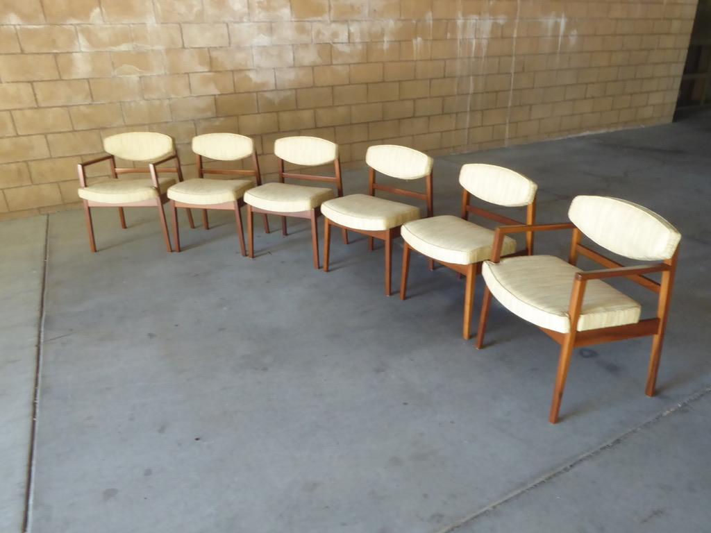 A rare and desirable set of six walnut framed dining chairs by design icon George Nelson for The Herman Miller Company C. 1950s. Four of the chairs retain the original Herman Miller labels. The set been restored and reupholstered in a multi-colored