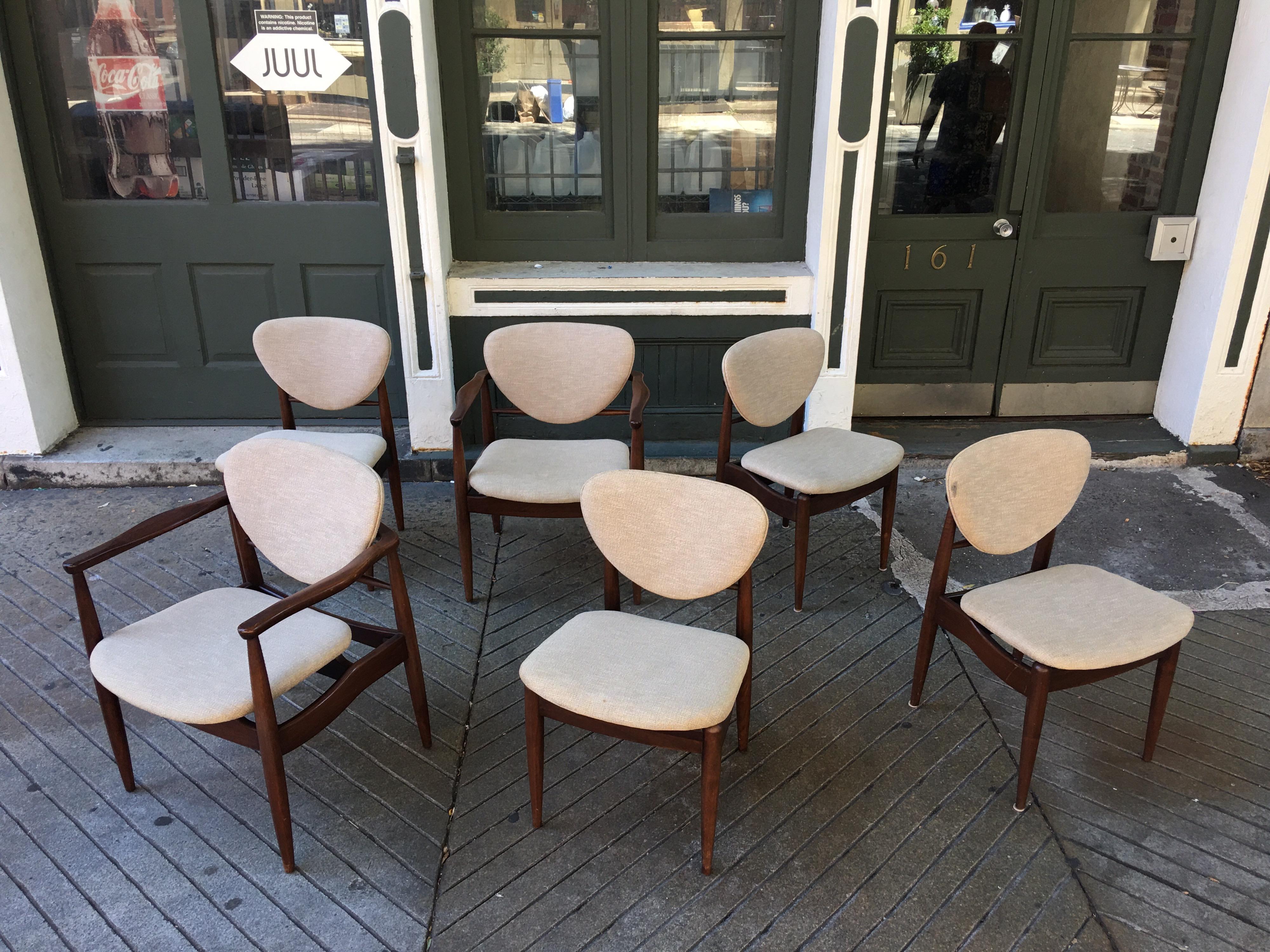 Solid Walnut John Stuart dining chairs in the style of Finn Juhl, 1960s chairs influenced by Finn Juhl's Classic Designed chair. Very solid with a nice cream upholstery. 2 armed, 4 armless armed chairs measure 24.5 wide. Measurements below are for