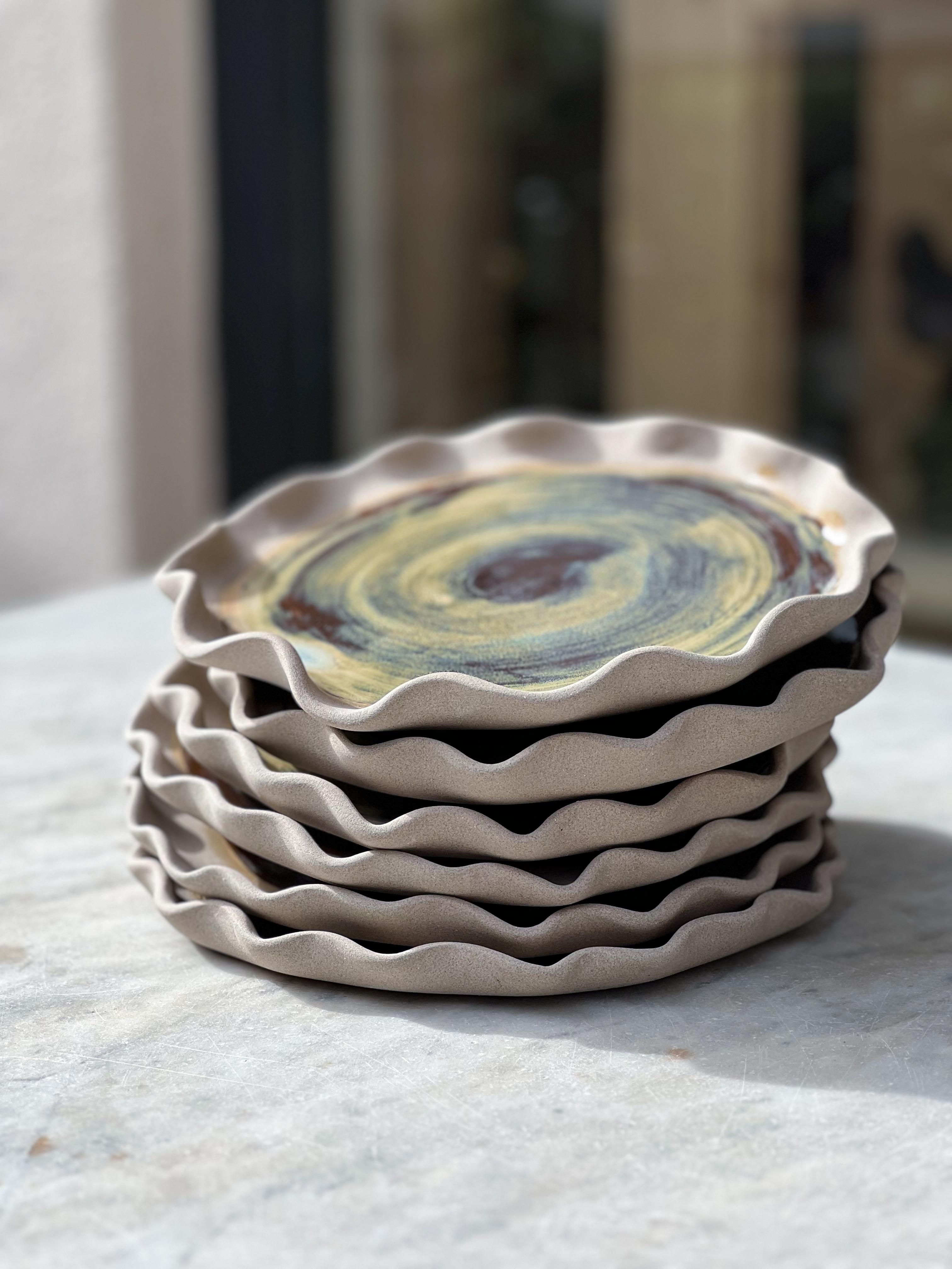Ensemble de 6 assiettes Vagues de la mer Égée par Güler Elçi
Dimensions : D 20 x H 1,7 cm
Matériaux : Céramique en grès, glaçure alimentaire.

Güler Elçi est une artiste céramiste basée à Istanbul. À la lumière de sa carrière d'ingénieur, elle