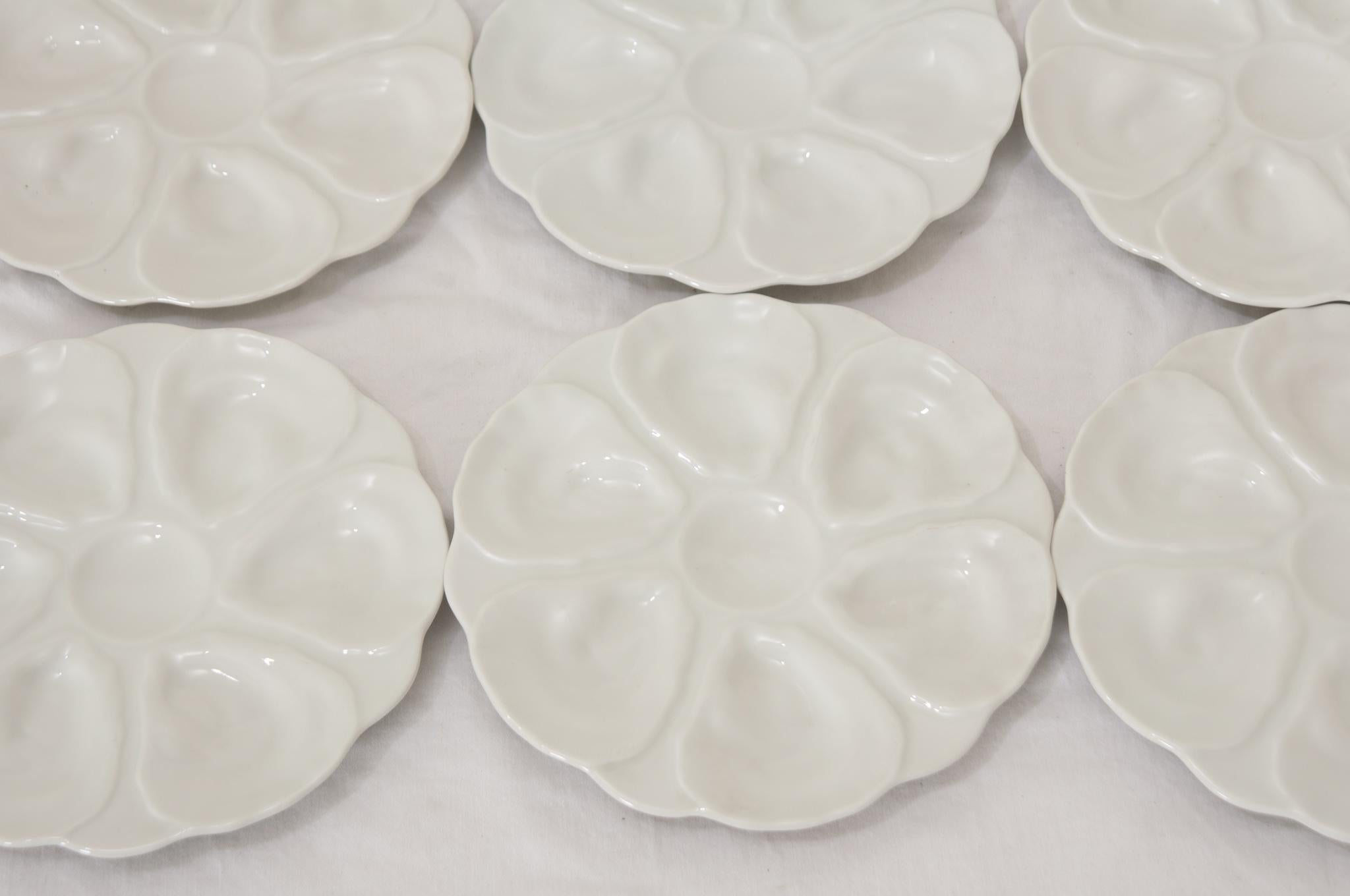 An elegant set of six French white oyster plates with fabulous glossy molded and shaped centers and scalloped edges. This set would be fabulous for serving or used in your interiors. Be sure to view all the images for a better look at these