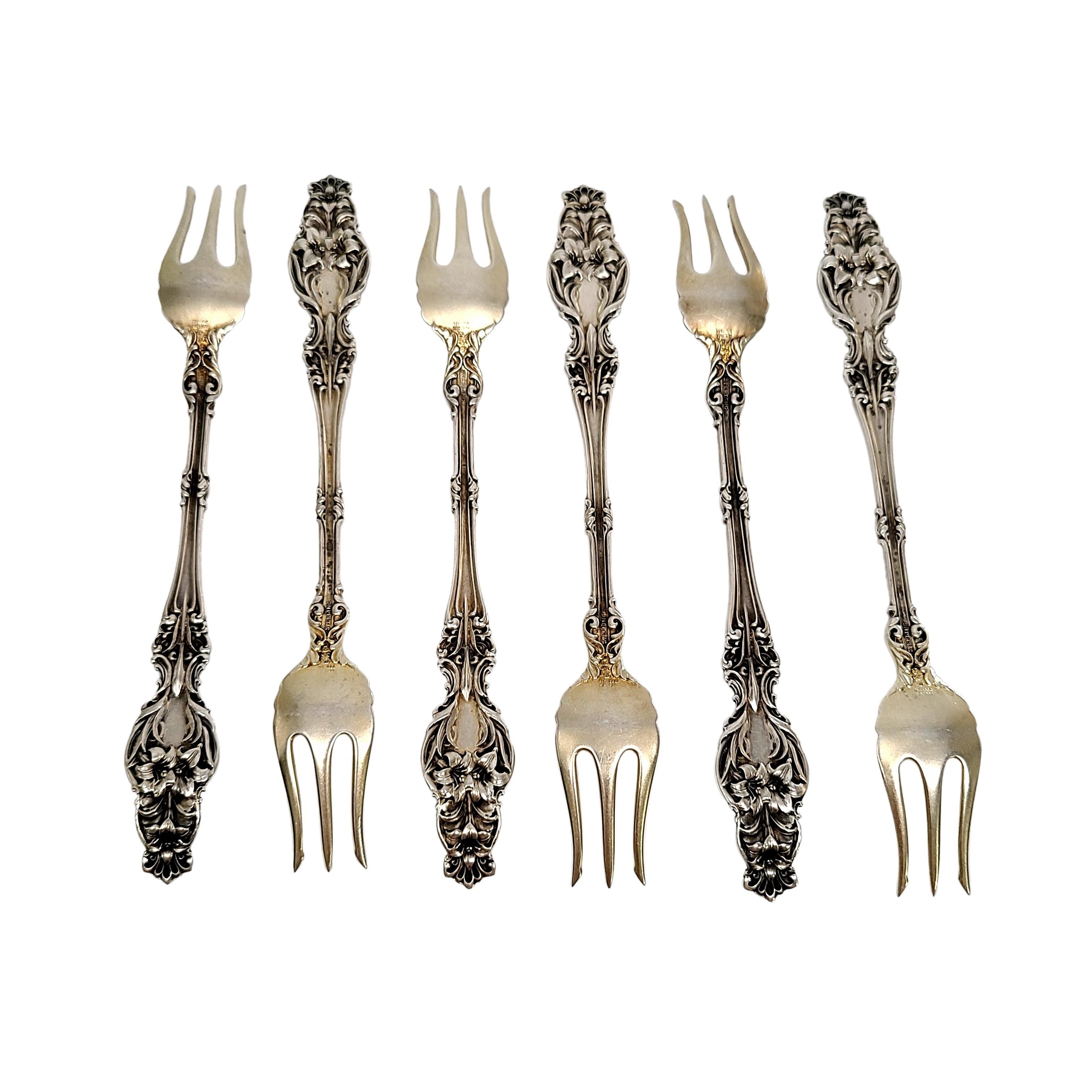 Set of 6 sterling silver cocktail forks in the Lily pattern by Frank Whiting.

Monogram appears to be G

Beautifully ornate set of forks in the Lily pattern with gold washed tines.

Measures approx 5 3/4
