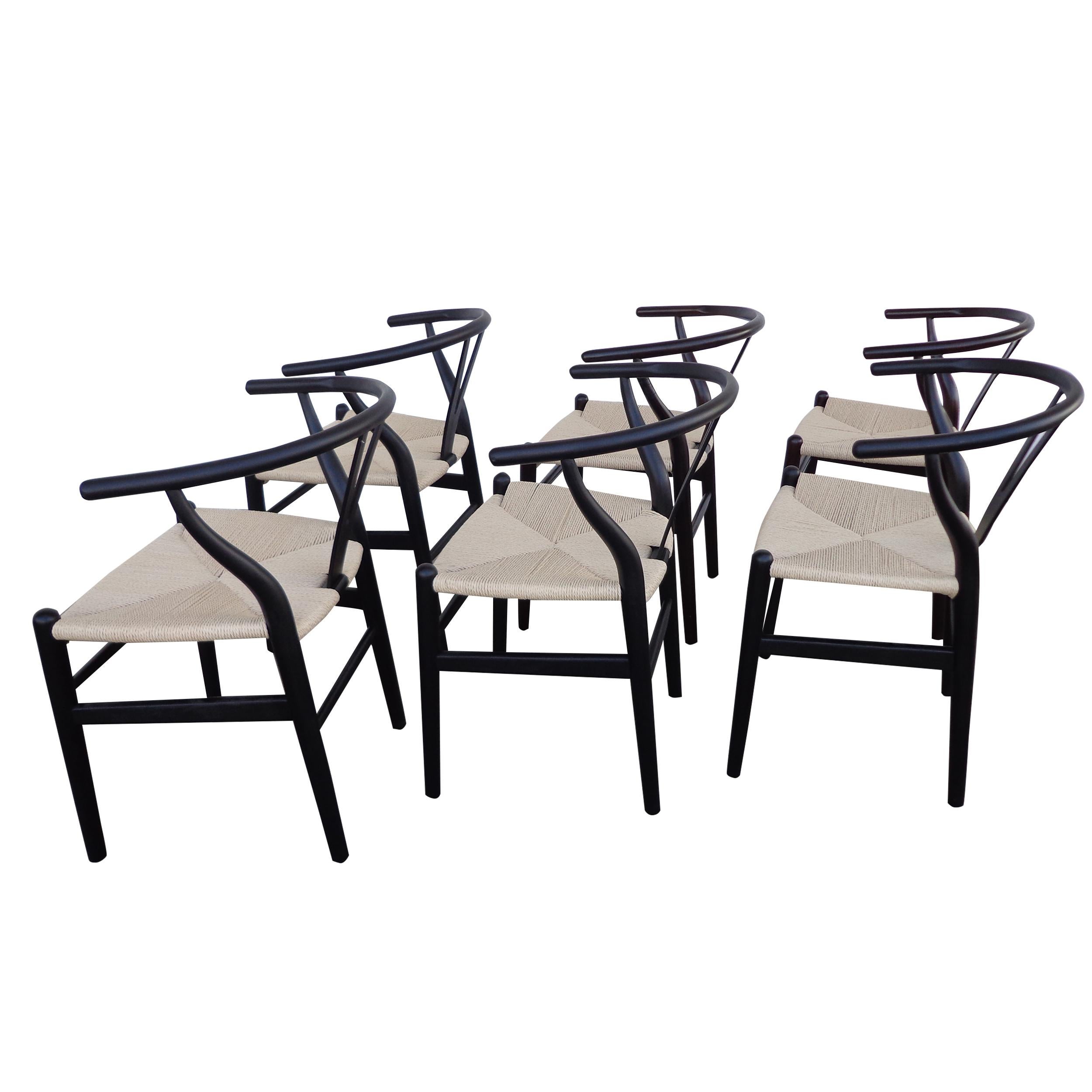 Set of 6 Wishbone style dining chairs 

This set of stylish wishbone chairs are lacquered in black with a woven seat in natural cord.

Measures: 18