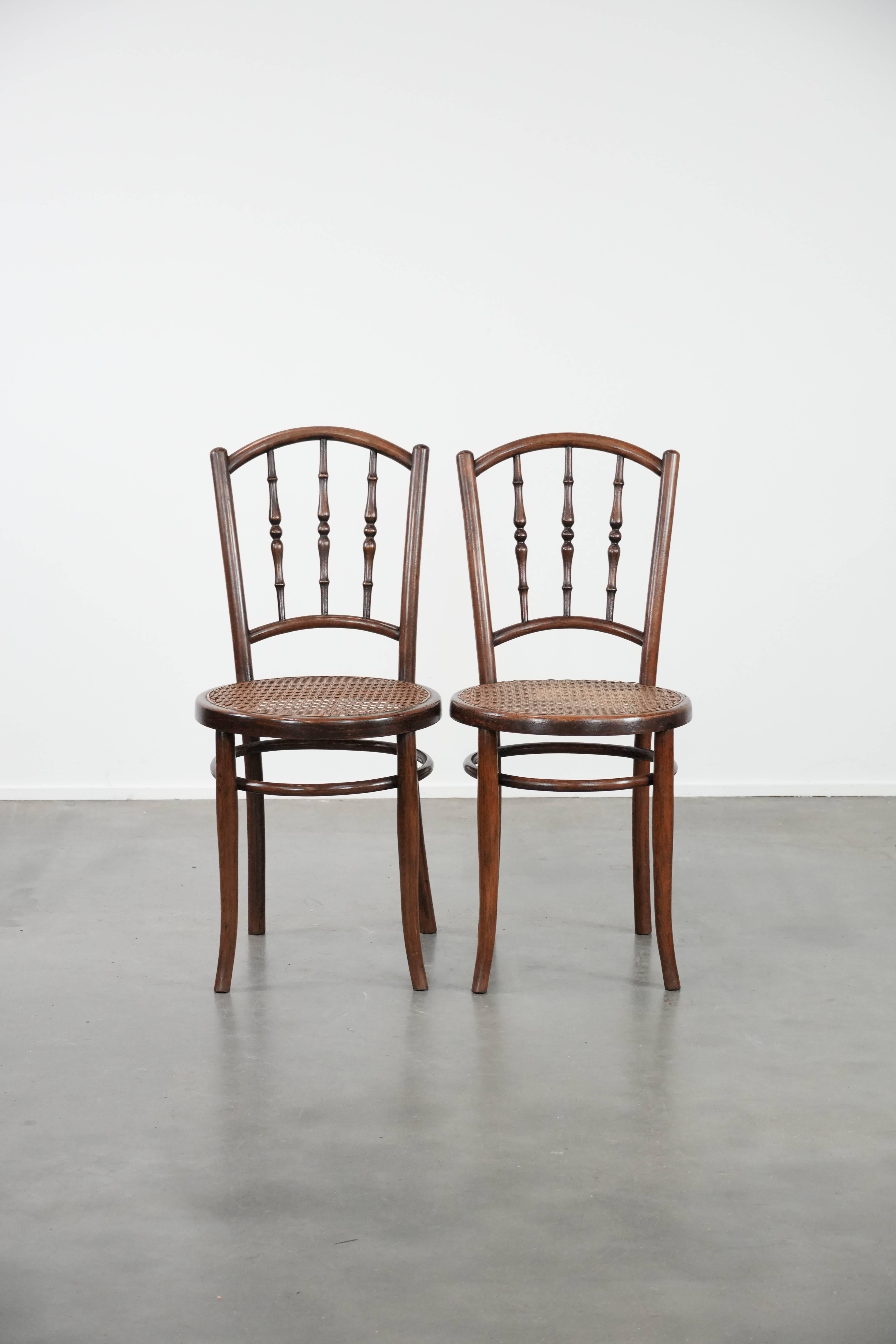 Dieses charmante Set aus 6 Stühlen von Jacob & Josef Kohn Wien zeichnet sich durch einen elegant geschwungenen Holzrahmen, eine Sitzfläche aus Schilfrohr und eine anmutige Rückenlehne aus, die den Stühlen einen zeitlosen und gemütlichen Look