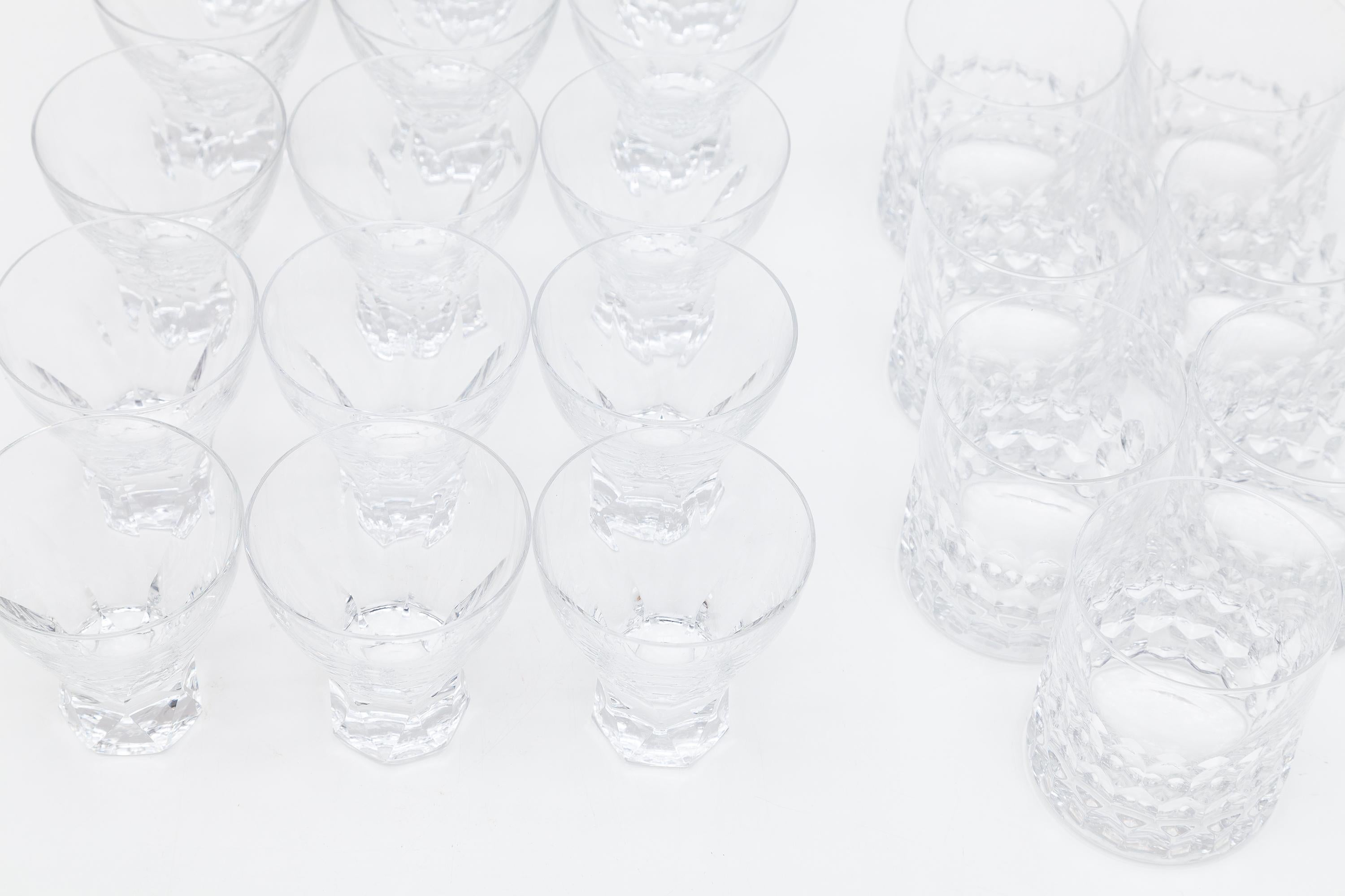 Vintage crystal glassware sets. Attractive cut crystal goblets in various sizes for cocktails and wine, and tumblers for highballs. 20th century handcrafted faceted crystal glass set circa 1960-1970 and very in the style of the exclusive French