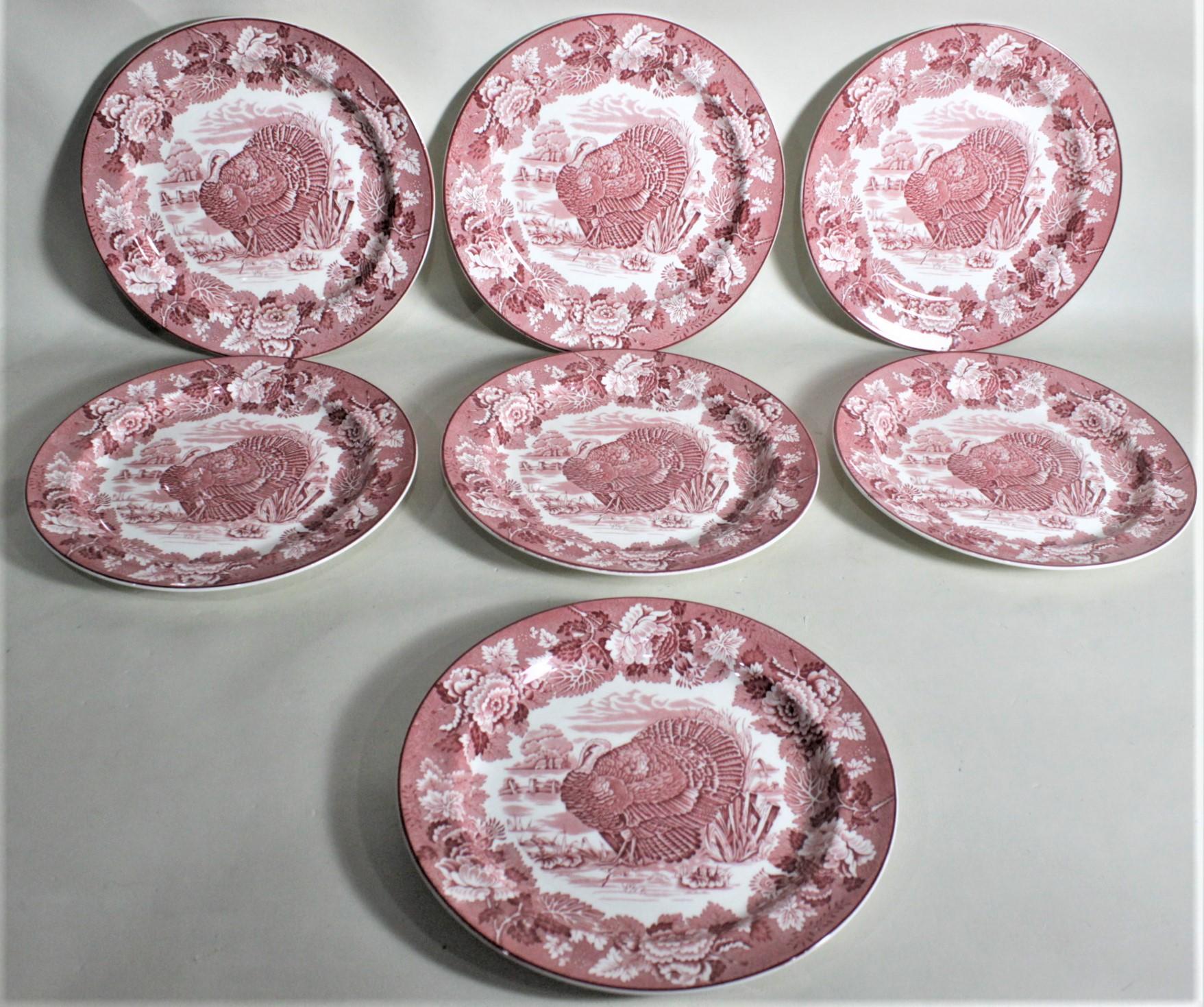 This set of seven antique ten inch dinner plates were made by Woods Burslem of England in circa 1880 in the Victorian style. Each plate is done in a red transferware on a cream stoneware ground and depicts a large male wild turkey in the foreground