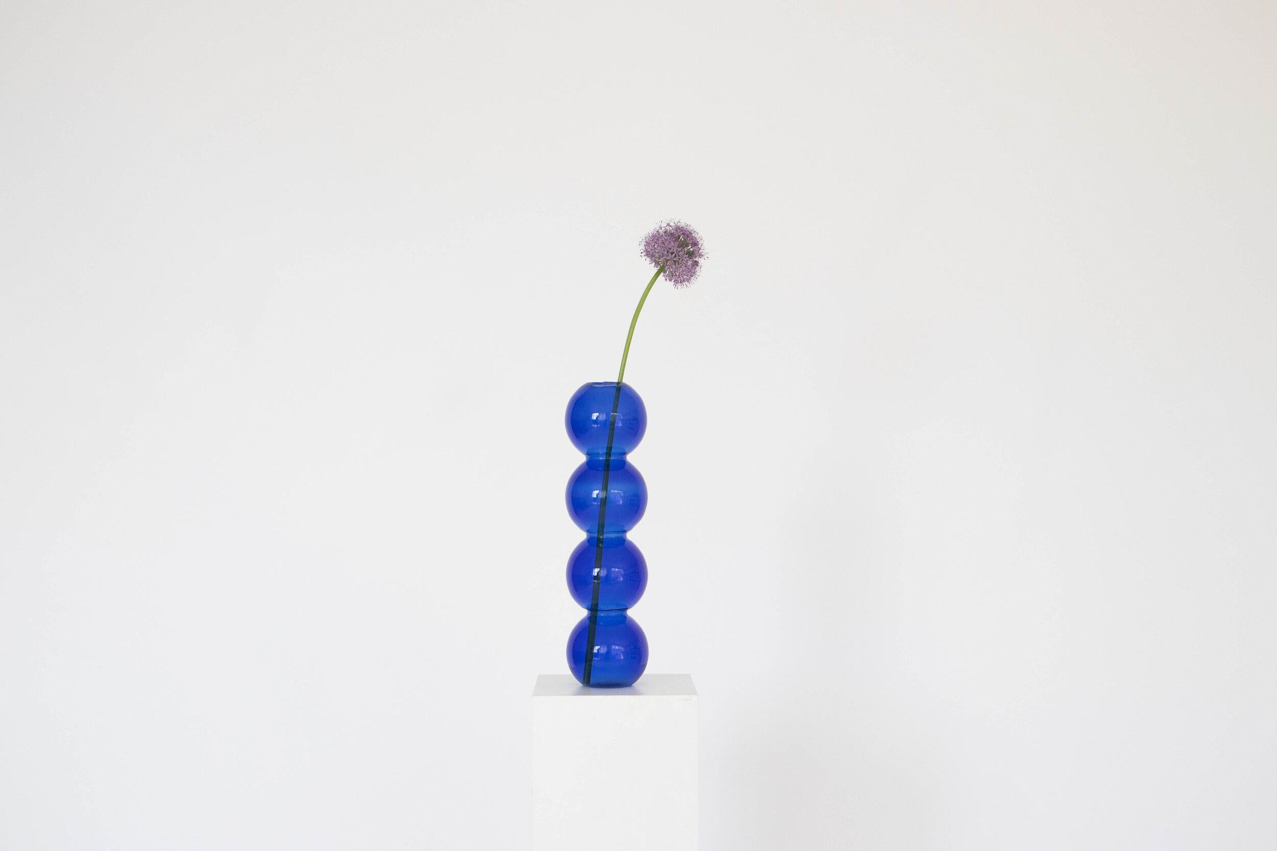 A set of 7 blue bubble vases by Valeria Vasi.
Handmade in Barcelona, 2021.
Materials: glass.
Dimensions: 38 x 10 cm.
Also available in: clear, teal, pink. 

A sculptural vase entirely crafted in Barcelona by a skillful local artisan using a