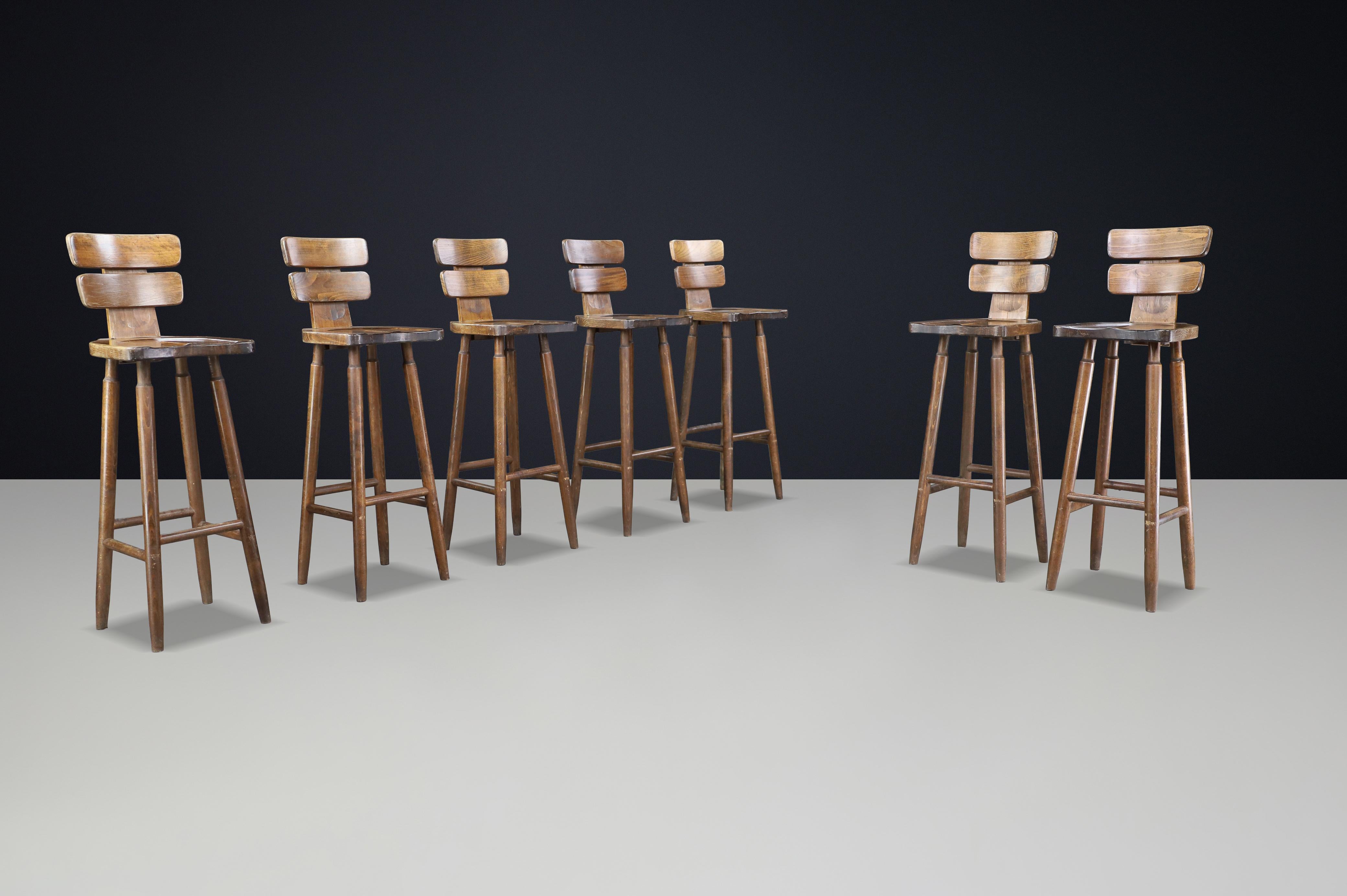 Set of 7 Brutalist Bar Stools in Patinated Beechwood, France, 1960s

A rare and character-rich set of seven Brutalist bar stools crafted in France during the 1960s. Executed in solid beechwood with a deep, natural patina, these stools reflect the