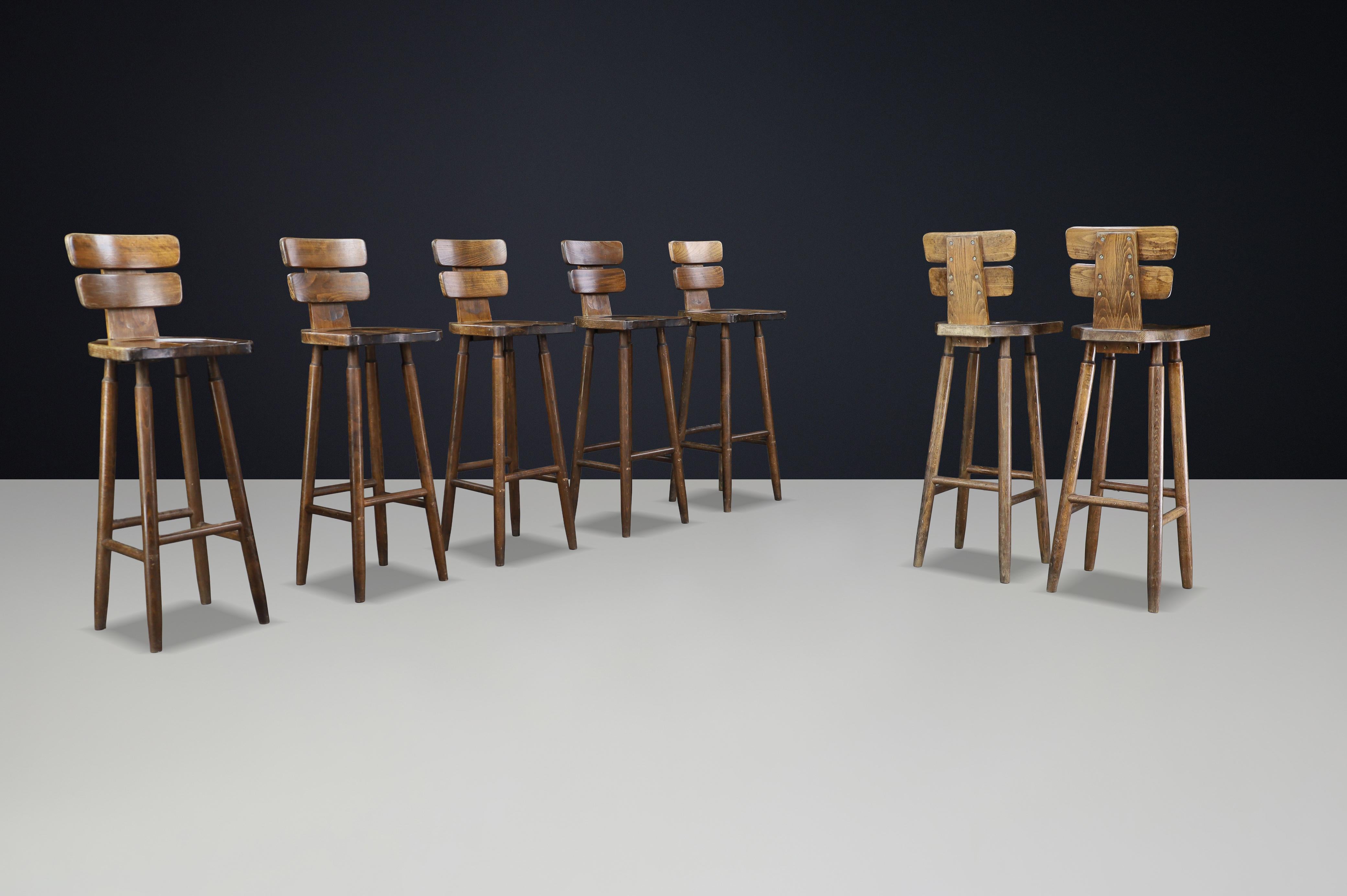 French Set of 7 Brutalist Bar Stools in Patinated Beechwood, France, 1960s For Sale