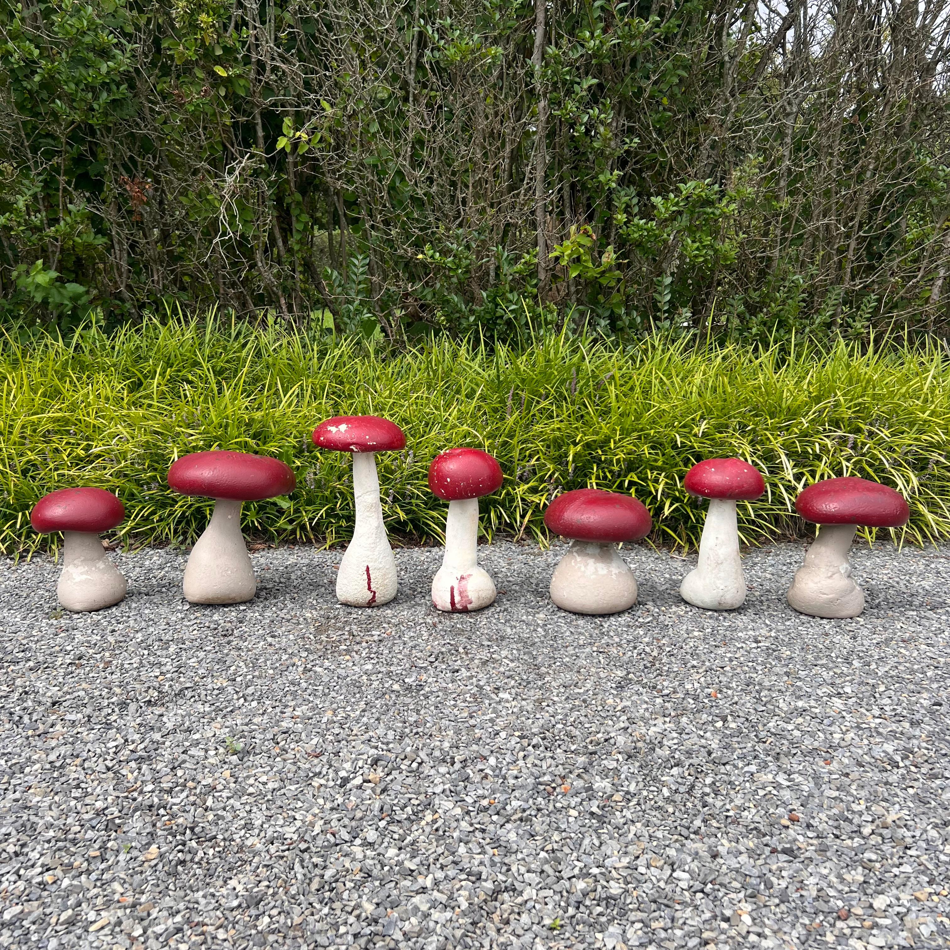 French concrete garden mushrooms, circa 1970s. Great for use outside. Age has given these unique items a light patina. Substantial and well made, these decorative mushrooms are constructed of solid concrete with candy red painted caps. A fun set of