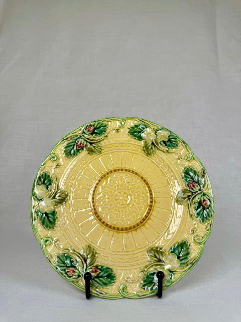This refined set of vintage French barbotine (majolica) dessert plates showcases the exuberant ceramic tradition of the late 19th century. Each plate features a soft yellow ground, delicately contrasted by ornate central medallions and raised floral