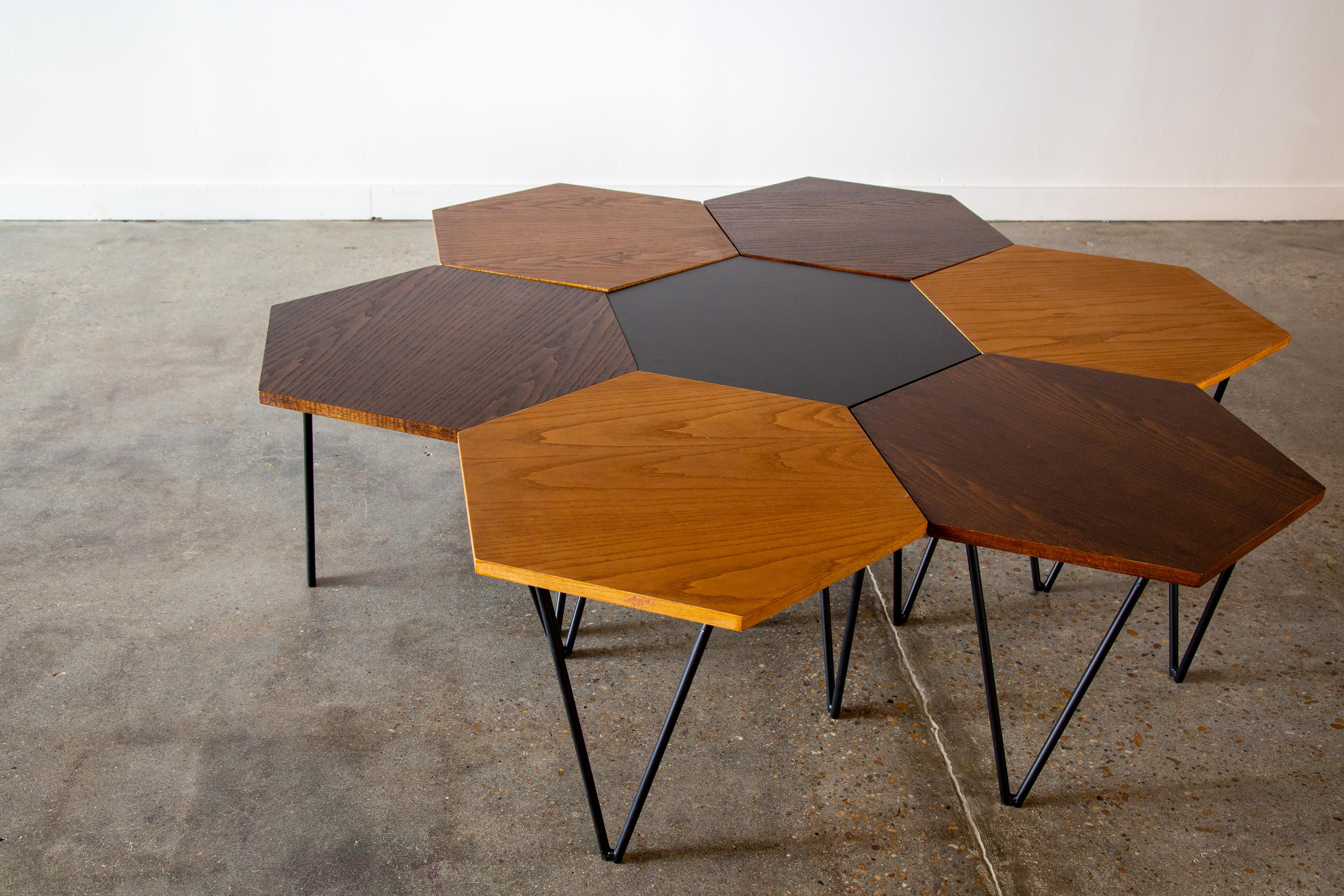 An exceedingly rare set of tables designed by Gio Ponti for ISA.  A tricolor blend of tops include black laminate, darker stained oak and a honey stained oak, perched on a tripod of hairpin enameled steel legs.  Each example retains its original