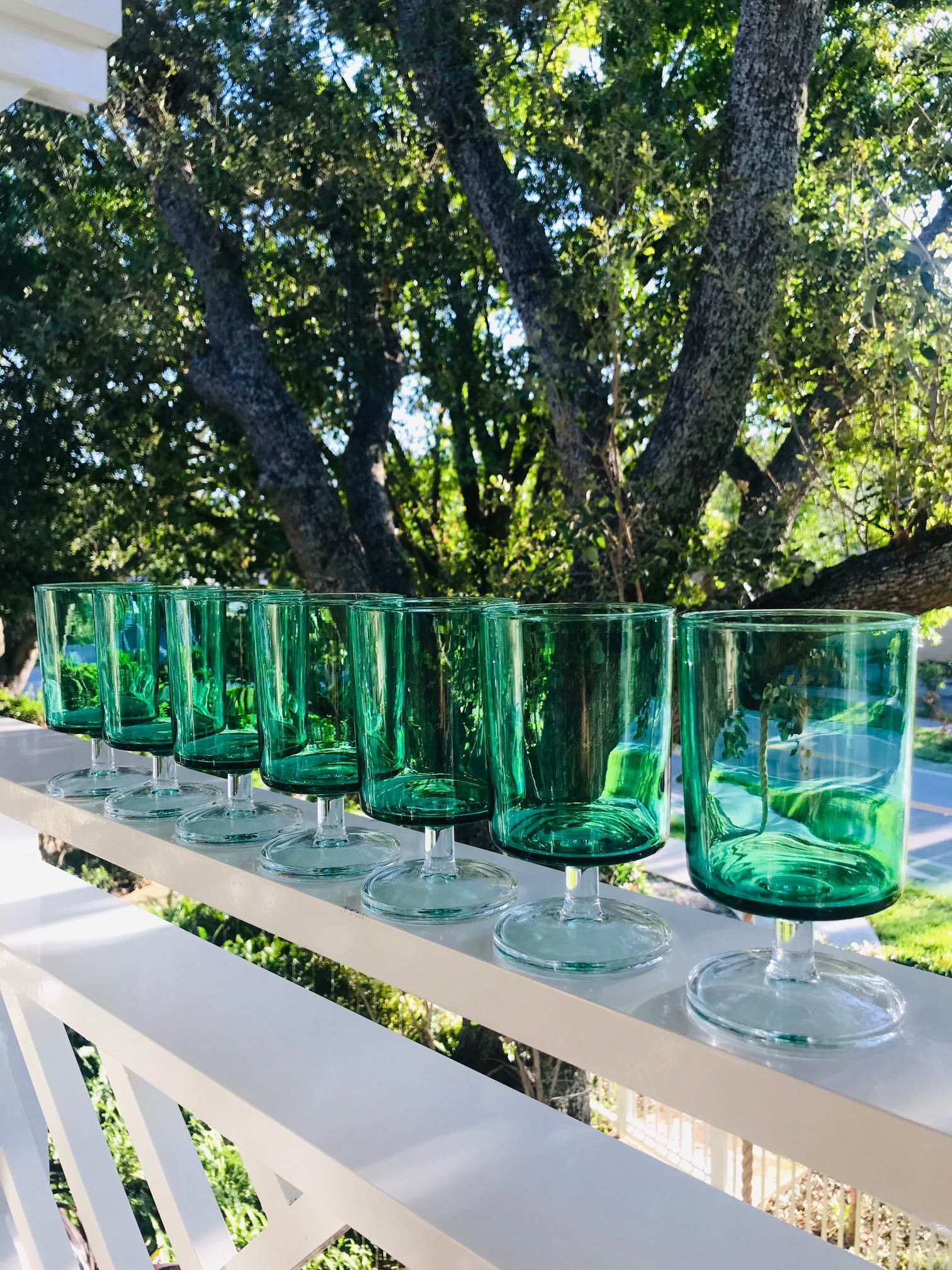 Set of seven vintage wine goblets in translucent green glass with clear crystal stems. Signed 
