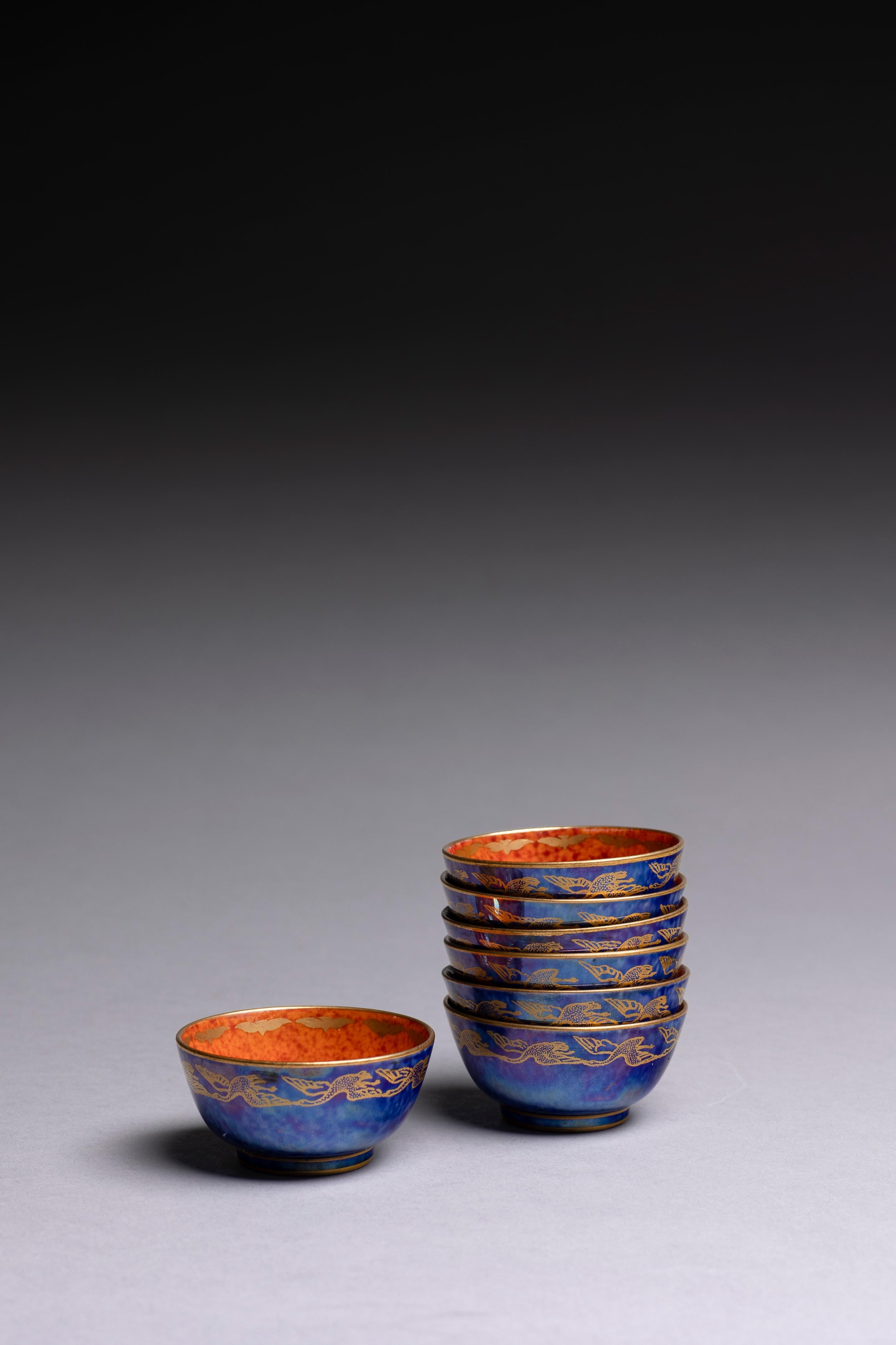 Un set di 7 ciotole in miniatura a lustro blu e arancione disegnate da Daisy Makeig-Jones per Wedgwood nel 1920 circa e decorate con il motivo 
