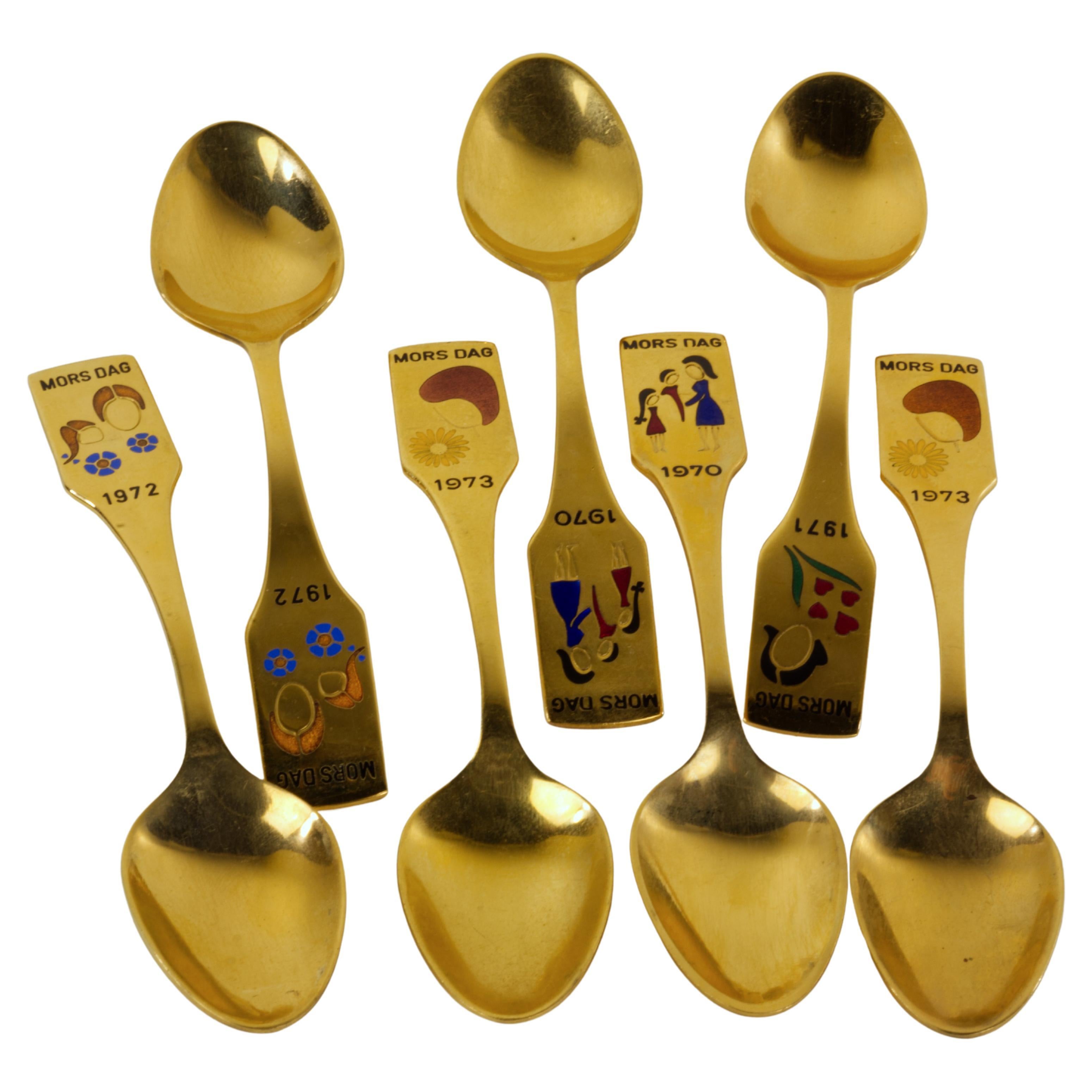  Set of gold-plated spoons with enamel decor consists of 7 limited edition spoons for years 1970 (1 spoons), 1971 (1 spoon), 1972 (2 spoons), and 1973 (2 spoons). Each year has a unique enameled design. The design was created by Falle Uldall
