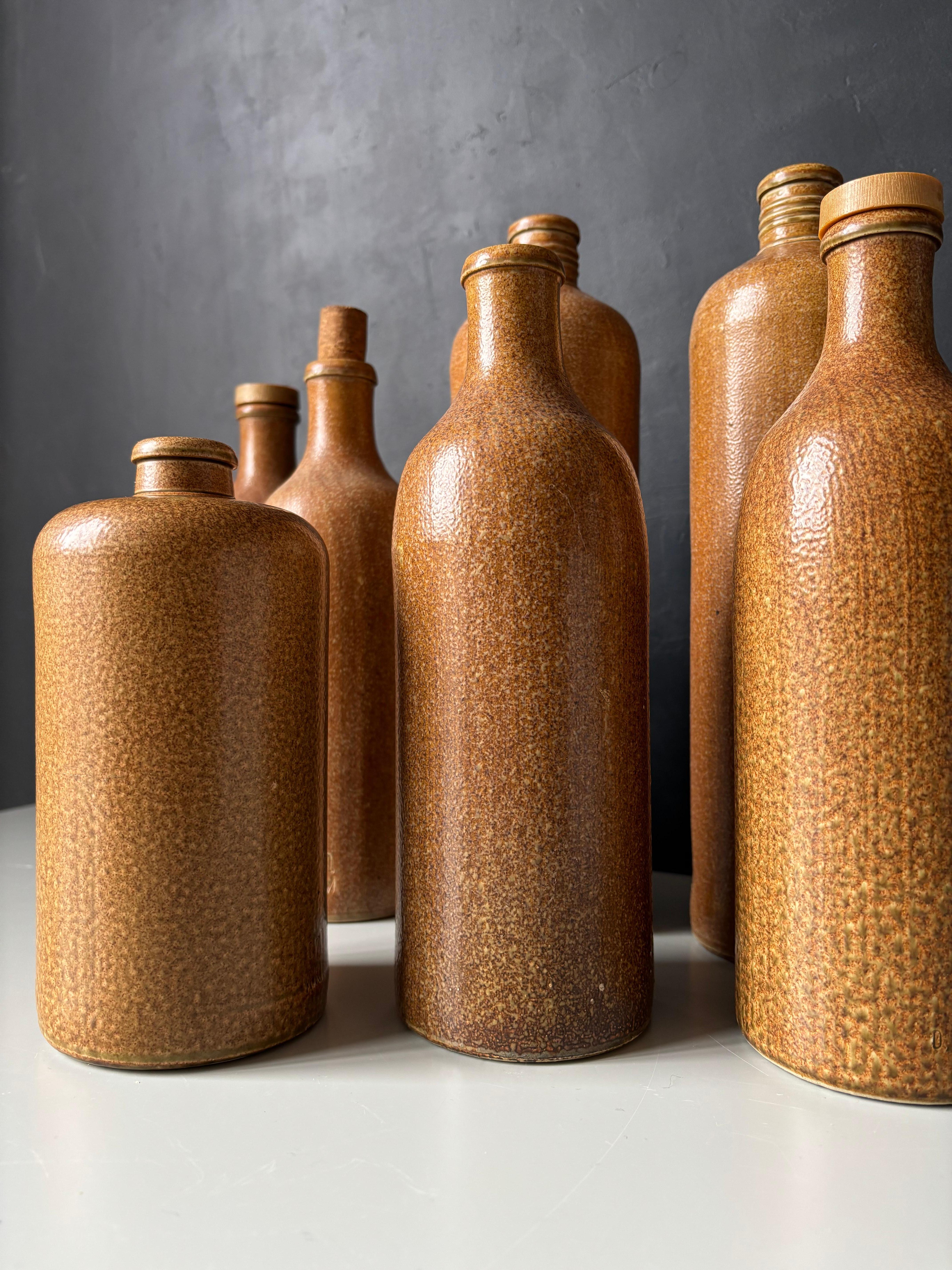Set di sette vasi decorativi in robusto gres, originariamente realizzati per contenere birra, vino e olio nell'Europa moderna della metà del secolo scorso. Prodotto da Max Krüger GmbH & Co negli anni '60. Smalto al sale cristallizzato di colore