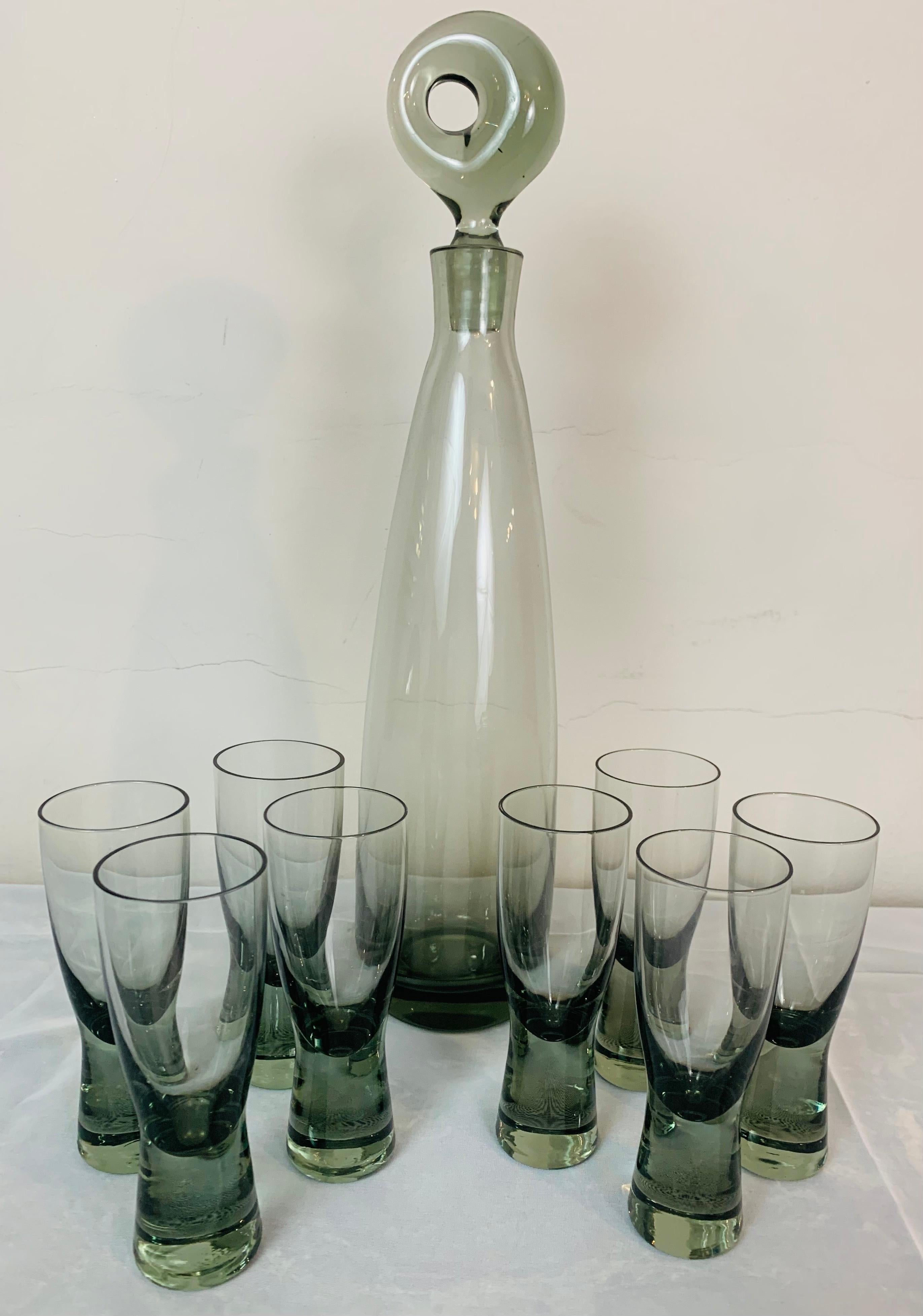 Set of 8 1960s Danish Holmegaard Canada smoked grey tinted aperitif/schnapps glasses and Aristokat decanter & stopper designed by Per Lütken. The glasses are from the Model Scanada range.

The Aristokat, an elegant, hand-blown, cylindrical,