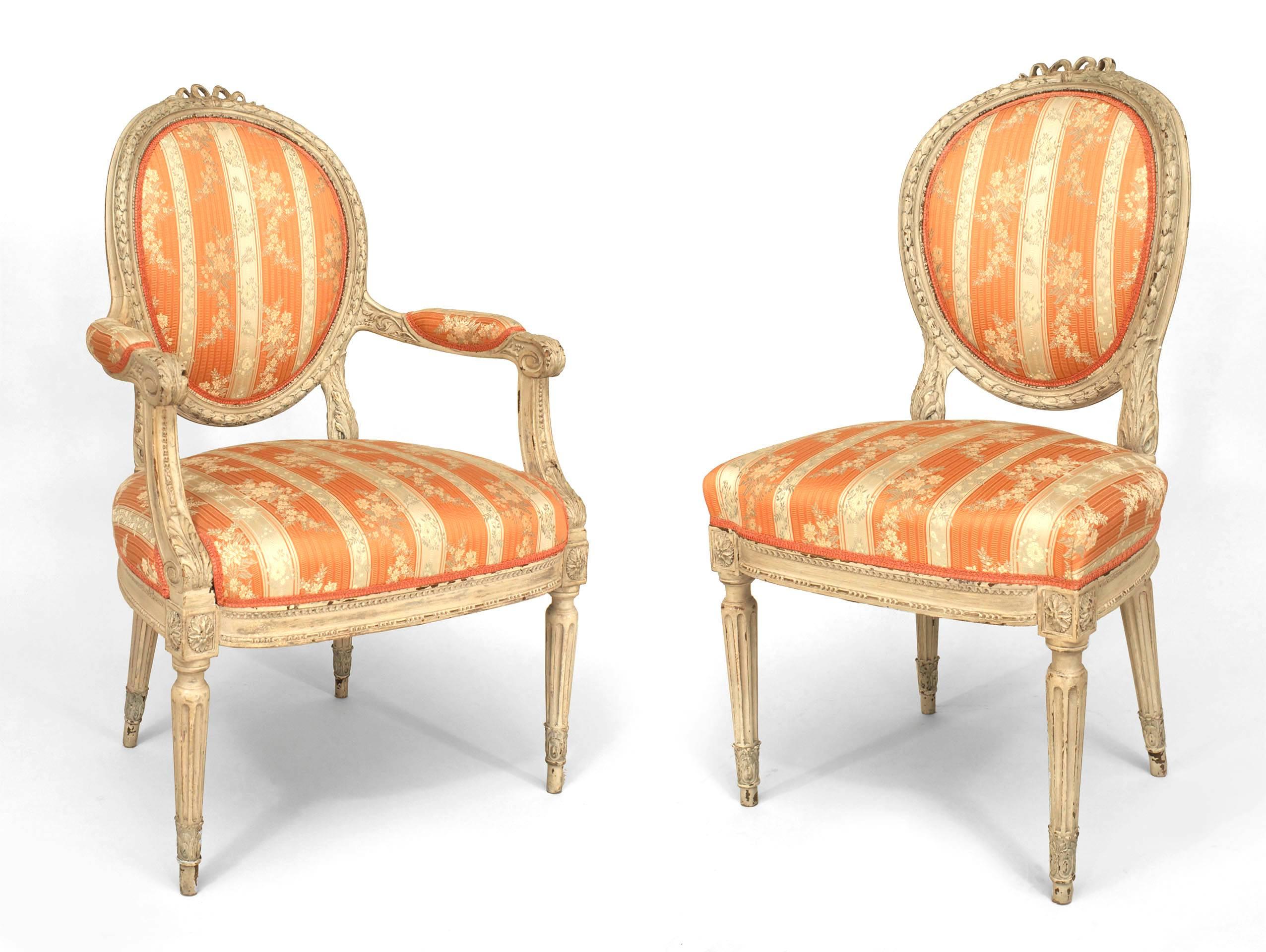 Set of 8 French Louis XVI style (19th Cent) white painted dining chairs with a carved bow knot top & oval back upholstered in pink & cream damask. (sides 20¬Ω