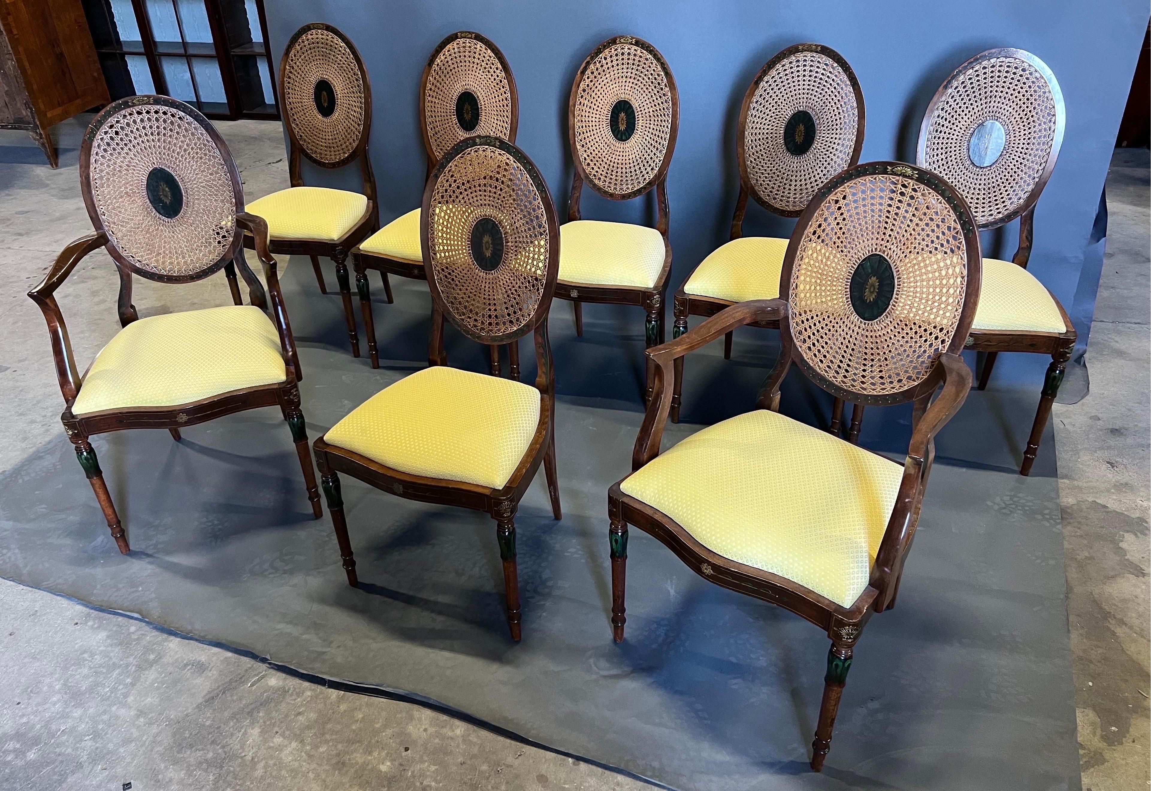 Very pretty and elegant set of 8 adams style dining chairs made of satinwood with cane backs and hand painted decoration. Cane is in great condition on all chairs and the slip seats are upholstered in an attractive yellow fabric but could easily be