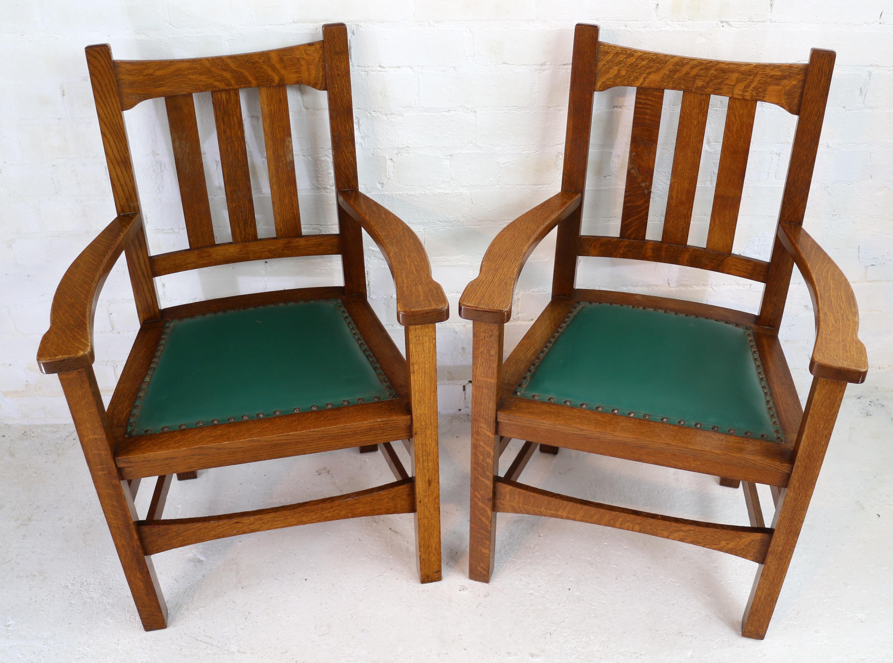 A rare set of eight Arts & Crafts Mission quarter-sawn oak dining chairs by Stickley Brothers and dating to circa 1900. Comprising two armchairs and 6 side chairs each with green pad seats with a hammered finish to the studs. With brass Quaint