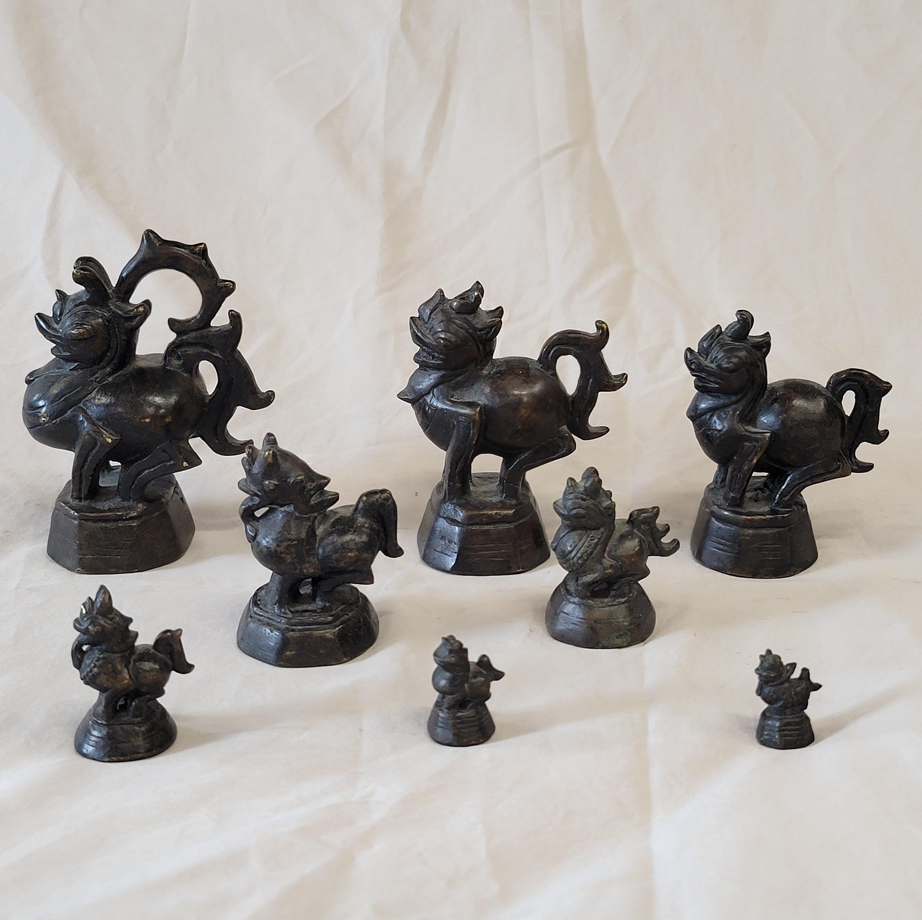 A charming set of eight antique Burmese dragon bronze opium weights. The largest weight measures4.25
