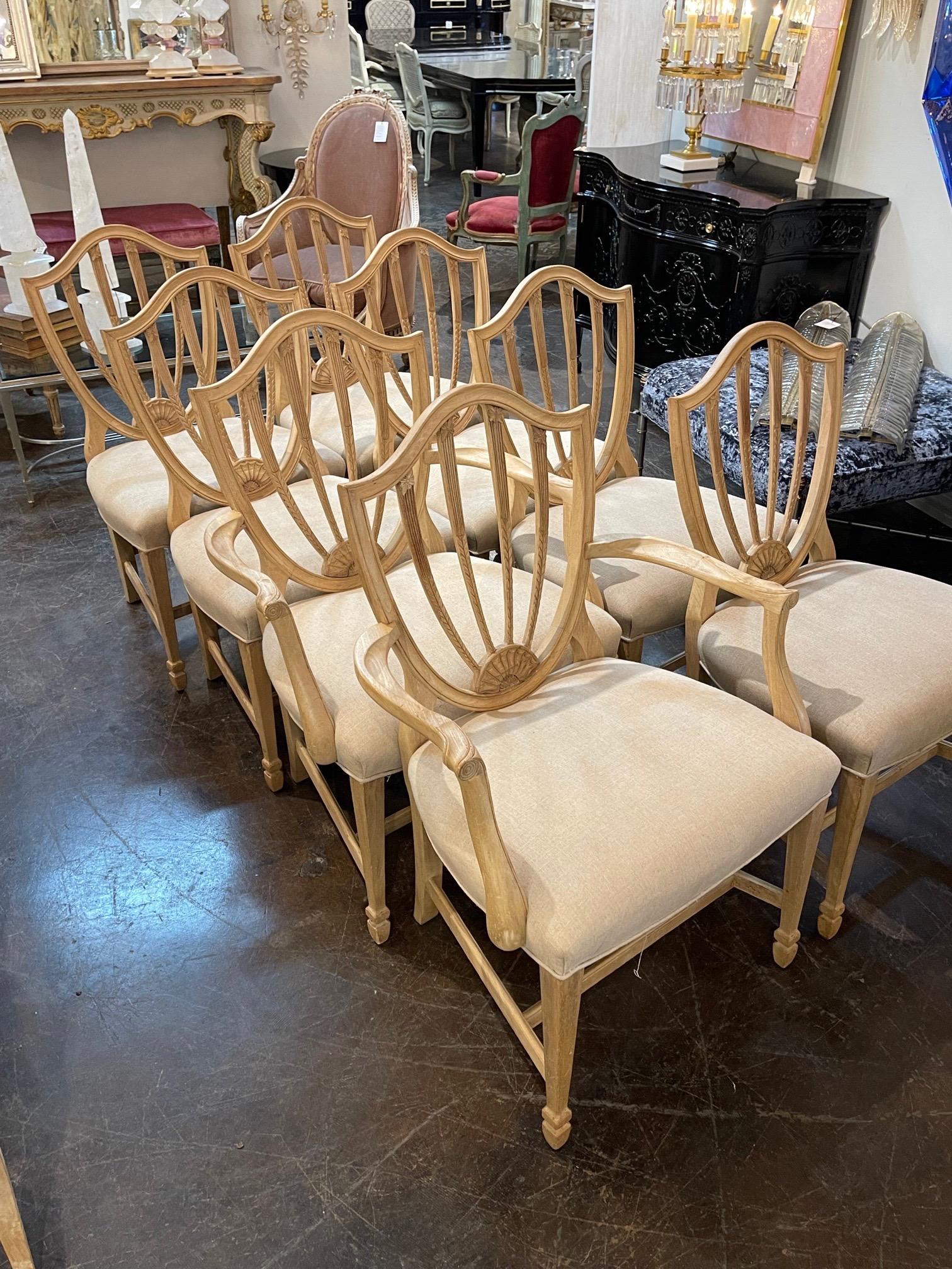 Very fine set of 8 English bleached mahogany shield back dining chairs. Nice carving and pretty beige linen upholstery. Great quality and comfortable as well!