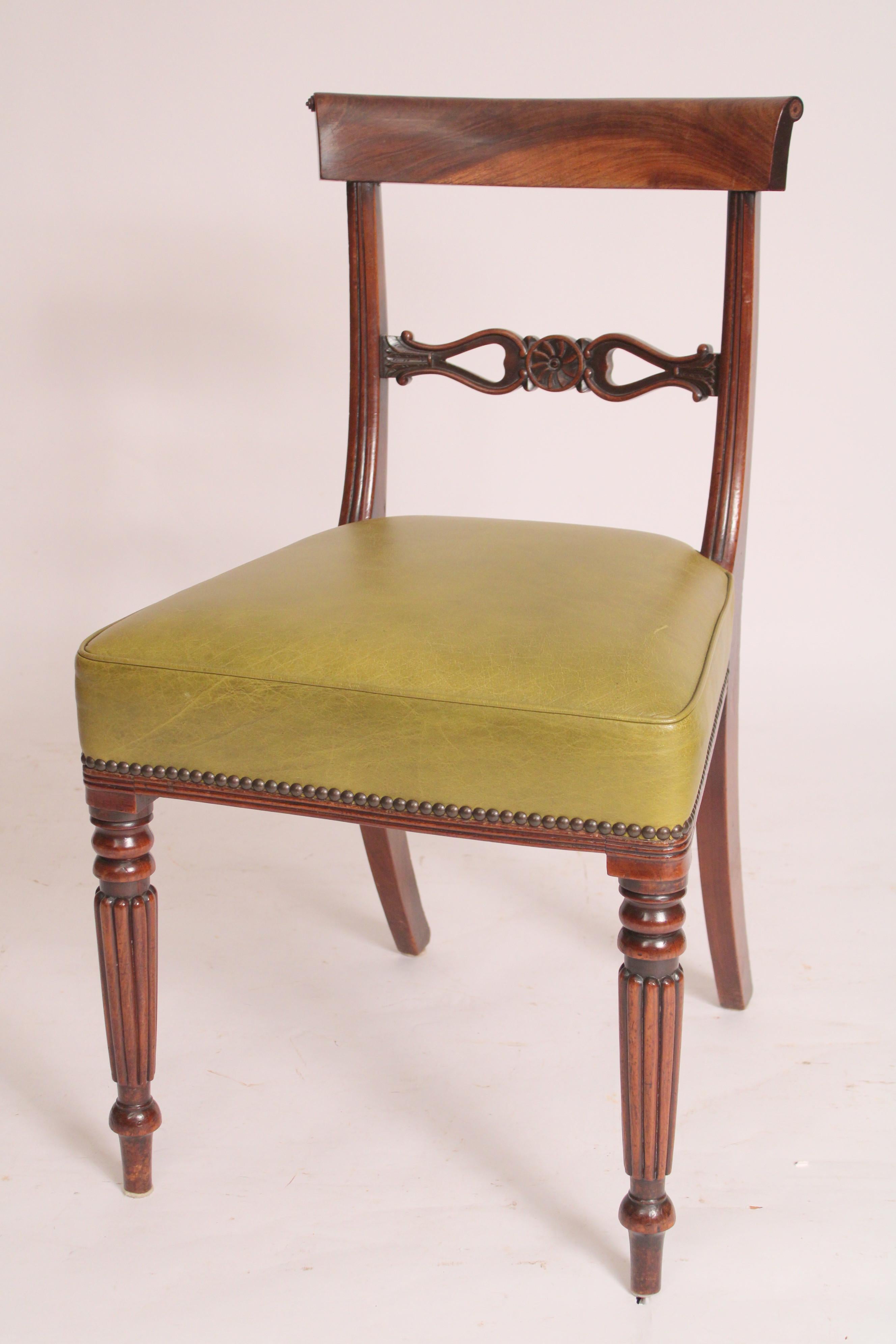 Set of 8 English Regencystyle mahogany dining room chairs, 19th century. With a concave crest rail ending in scrolls, back splat with a central floral design, seats recently re upholstered in faux leather resting on turned tapered reeded legs.