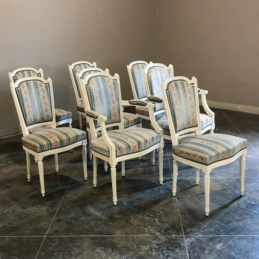 Set of 8 antique French Directoire chairs includes 2 armchairs feature patinaed painted finishes that enhance their understated elegance rendered with hand carved detailing from solid mahogany. Tapered and fluted legs provide support, with more