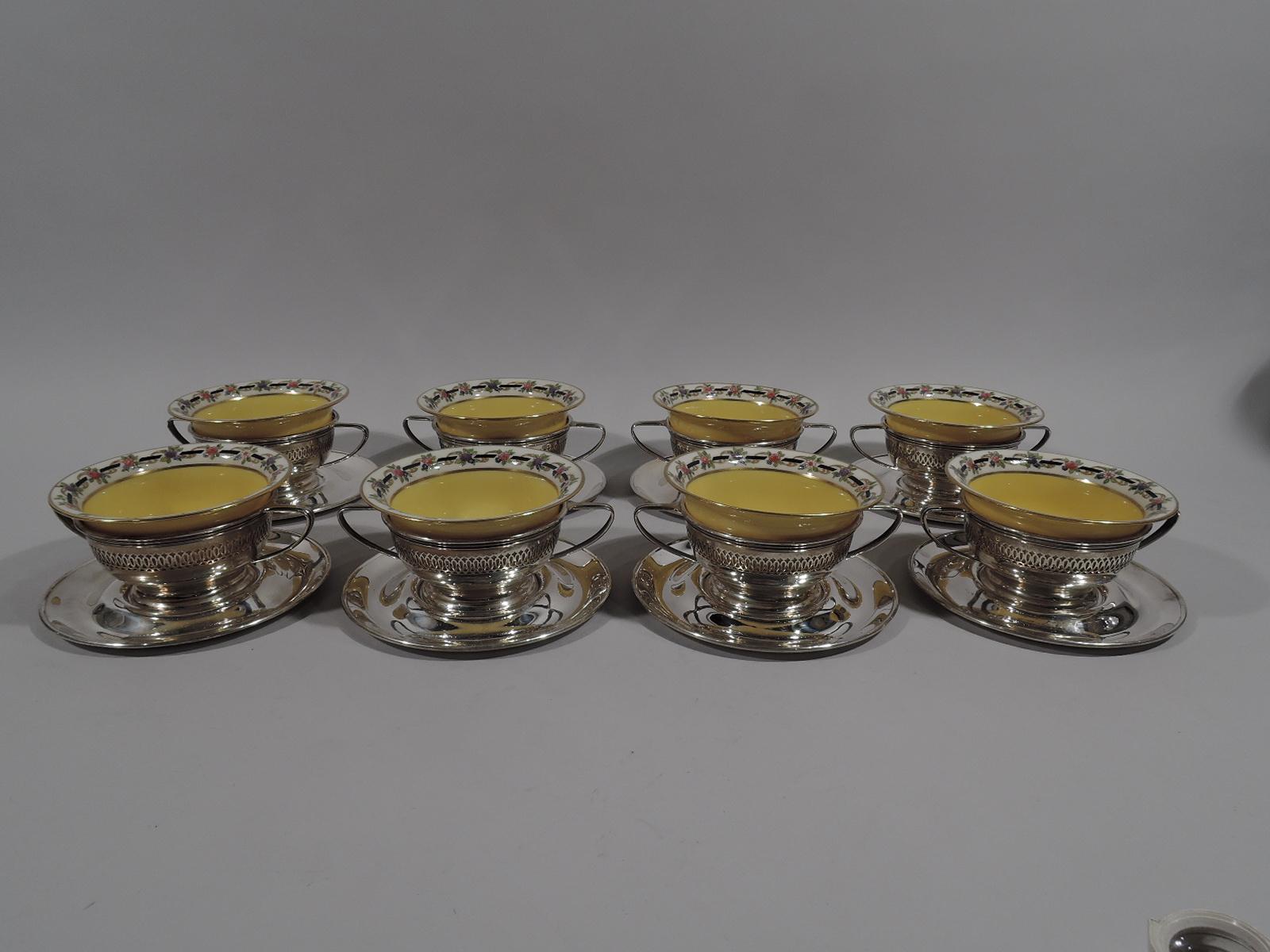 Set of 8 Edwardian sterling silver bouillon holders and plates. Made by Gorham in Providence in 1919. Each holder: Round and curved with pierced border, elongated scroll bracket handles, and spread foot. Each plate: Well and concave surround. Plates