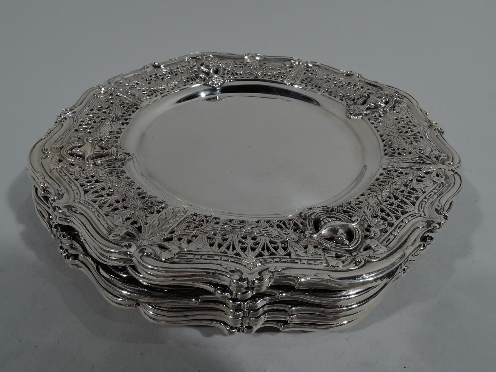 Set of 8 Edwardian Regency sterling silver bread & butter plates in Adam pattern. Made by Shreve & Co. in San Francisco, ca 1915. Round and plain well. Wide shoulder with Classical vases on open rondels joined by leaf swag on pierced fern ground.