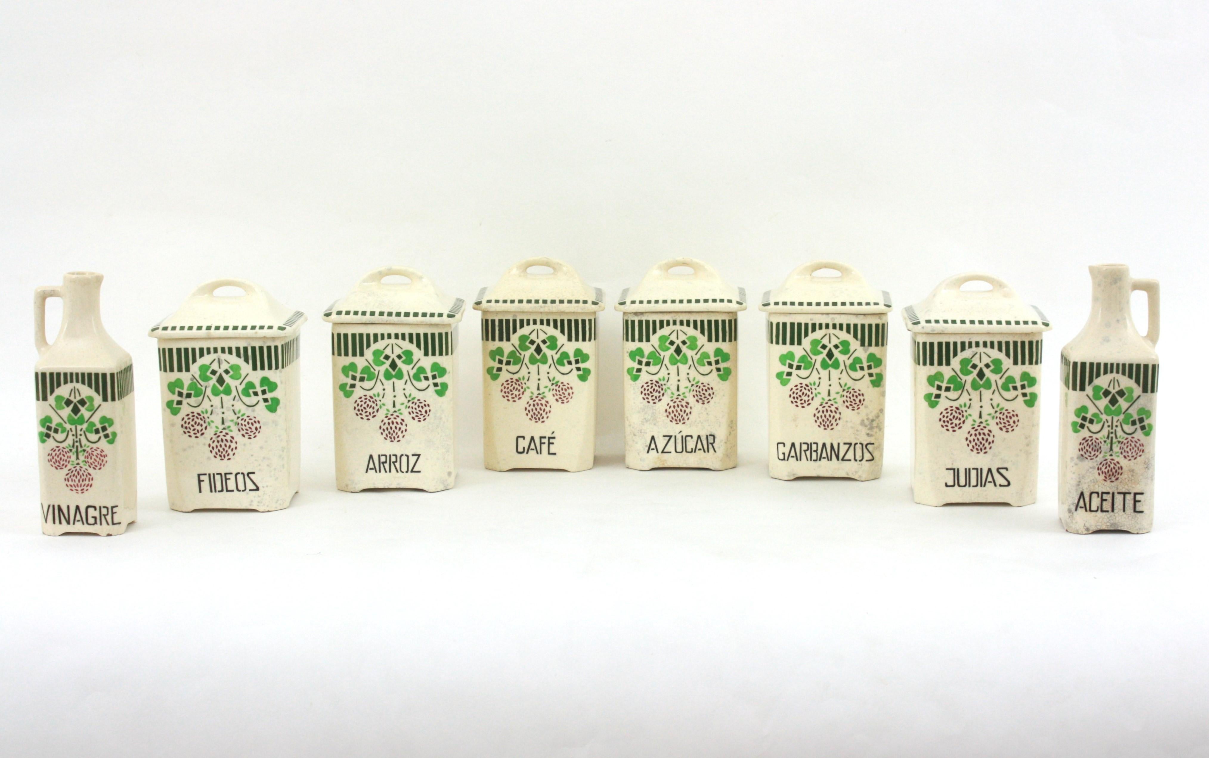 Set di 8 barattoli da cucina in ceramica smaltata. Spagna, anni '30
Raro da trovare.
Realizzato a mano in ceramica bianco sporco con iscrizioni in marrone scuro e dettagli decorativi floreali dipinti nei toni del verde e del granato.
Un set