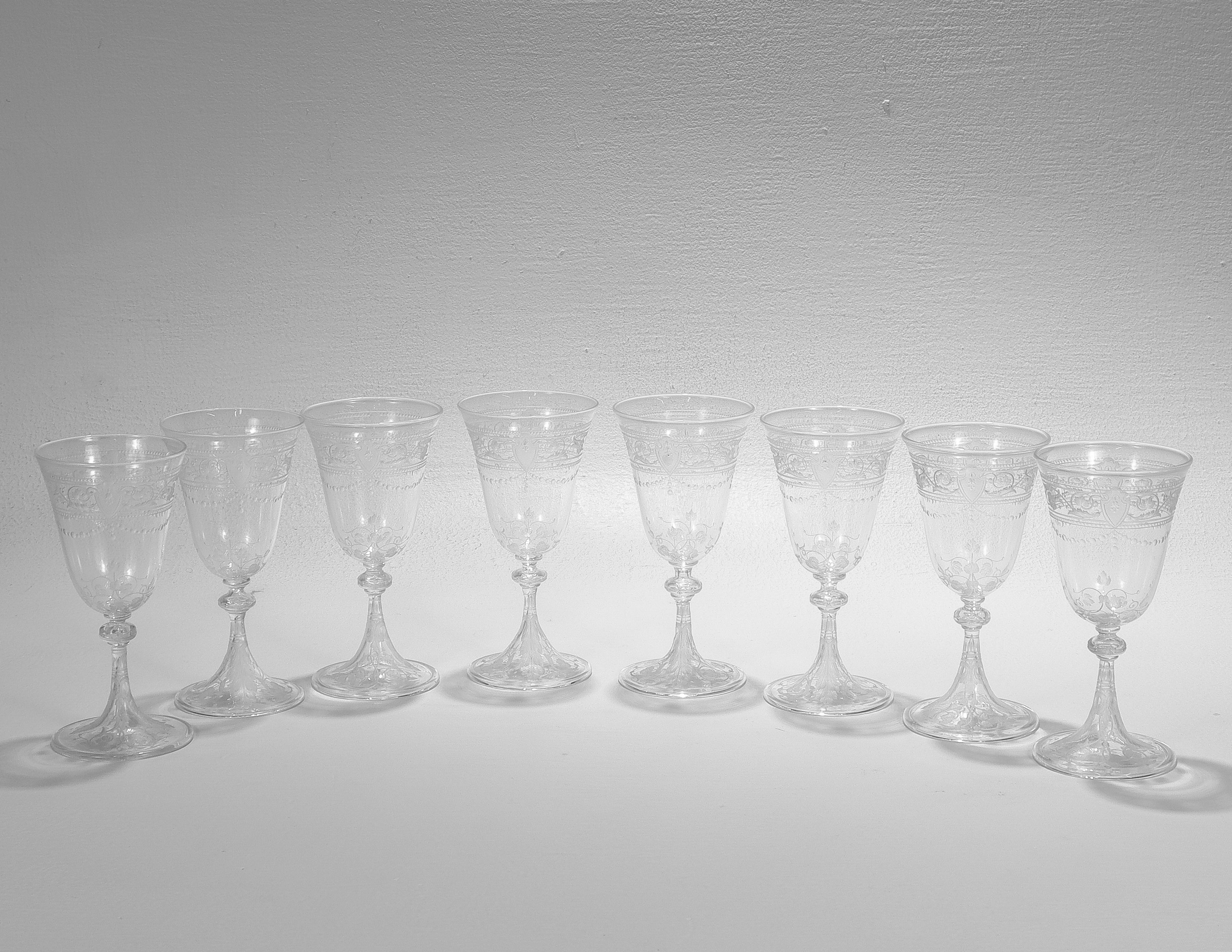 A fine set of antique etched and engraved glass wine glasses.

Attributed to Stevens & Williams or Webb.

With engraved & etched designs trelliswork, flowers, and shield devices.

Each with a shaped rim and curved handle.

Simply a wonderful