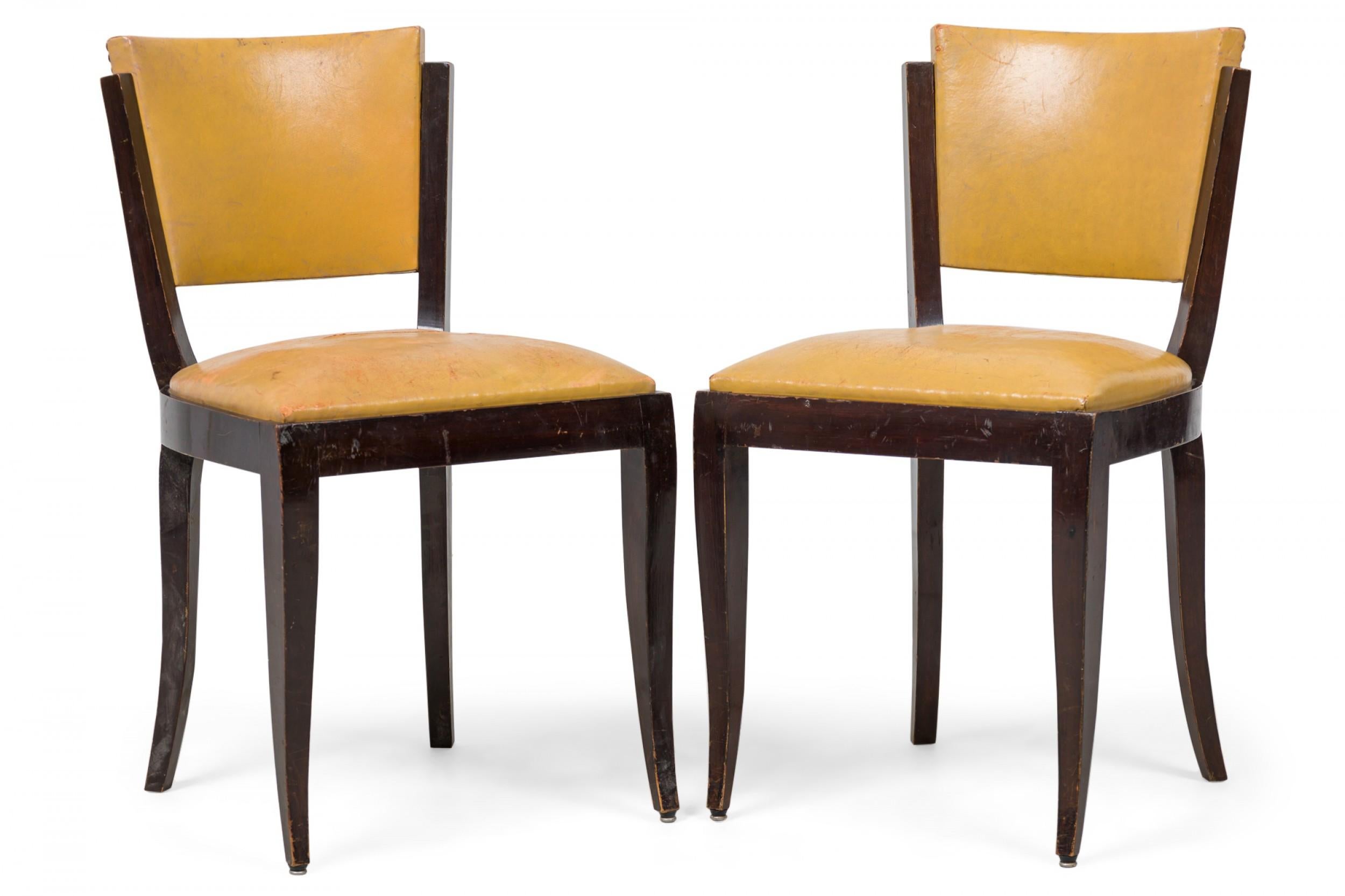 SET of 8 Art Deco American dining / side chairs with a curved trapezoidal backrests and padded seats upholstered in gold vinyl upholstery plus brass nailhead trim, standing on 4 splayed, curved legs. (PRICED AS SET).