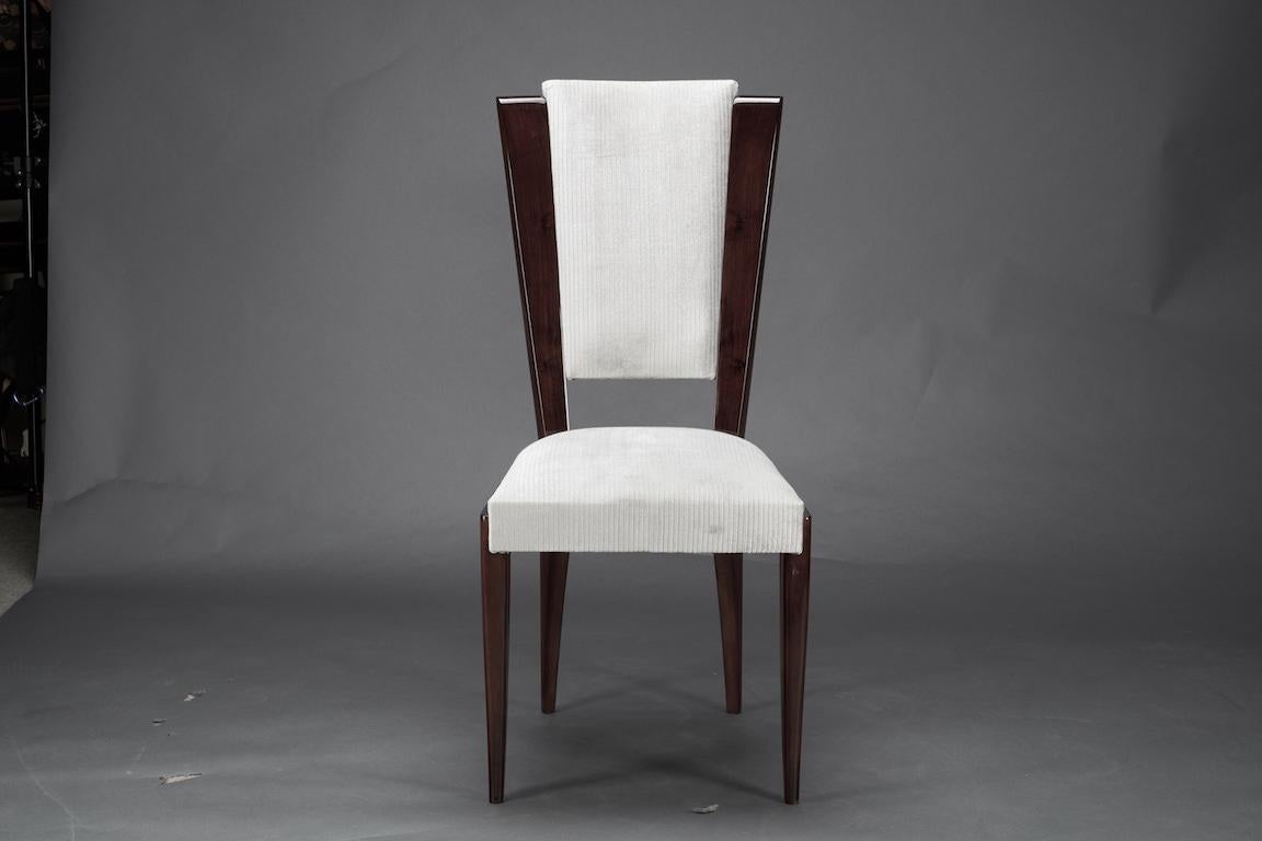 Dinning chairs are newly re-upholstered in a light fabric. Made out of high quality walnut wood. 
It is elevated by 4 slim elongated legs. Back of the chair is exposing wood on the sides, which creates juxtaposition of light fabric and dark