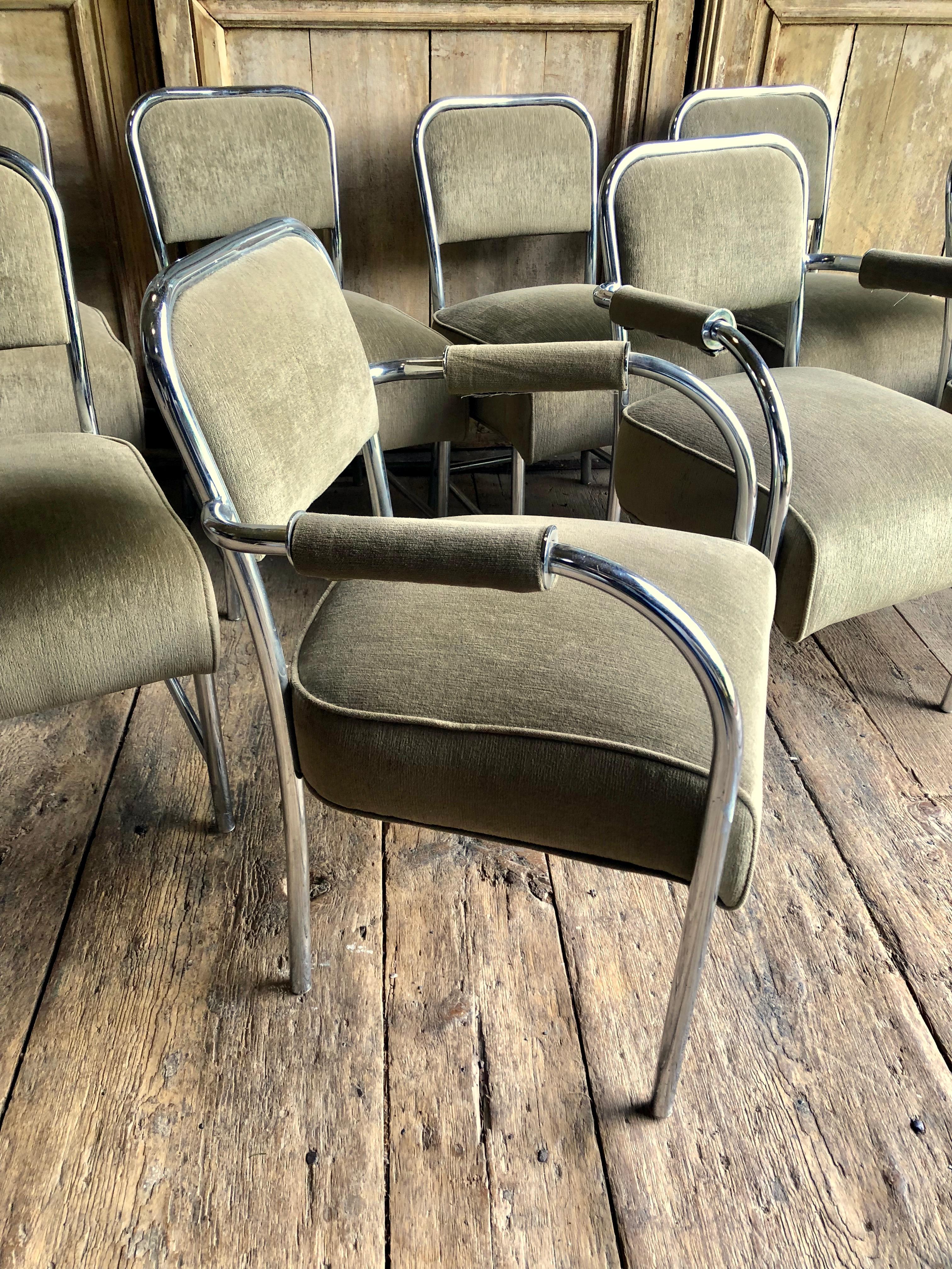 A set of eight (2 armchairs - 6 side chairs) chrome played tubular steel dining chairs with upholstered seats and backs, covered in a sage green velour fabric. The chairs are in the manner of Gilbert Rohde and date from the 1950s.