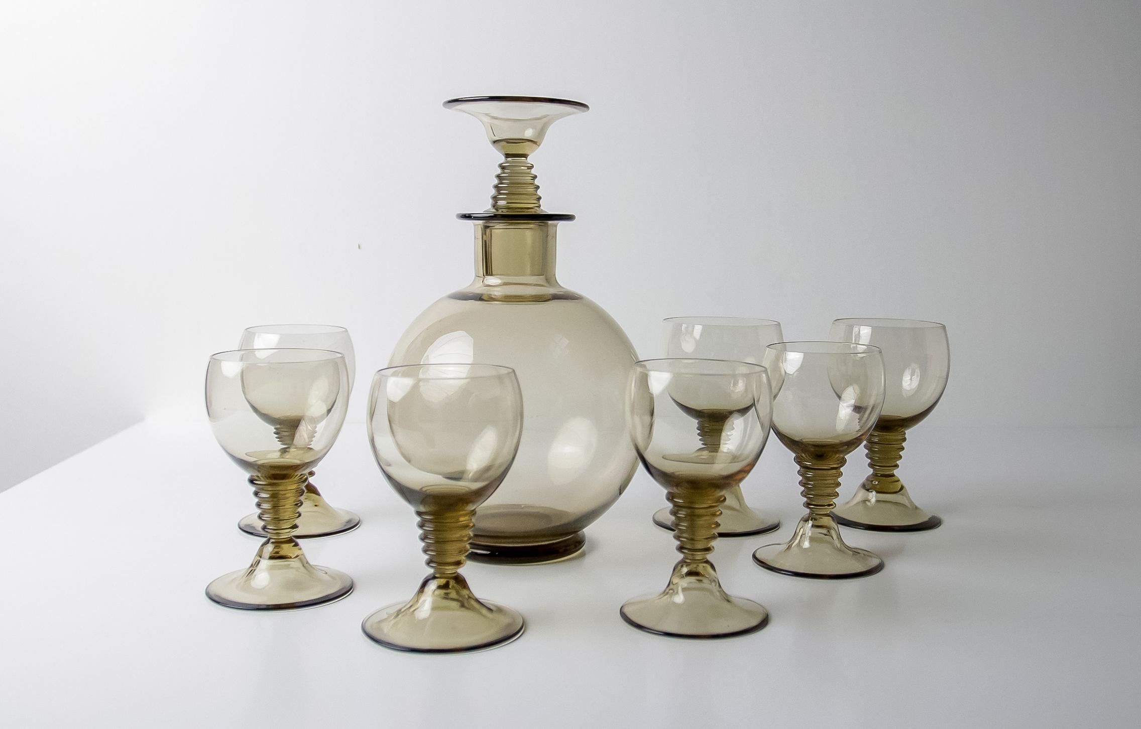 Beautiful little decanter (21cm high) and 7 glasses, two slightly bigger, designed by Willem Jacob Roozendaal in 1932 for Kristalunie Maastricht.
The set contains 8 pieces and all in a good condition with little traces of use.

Keywords: