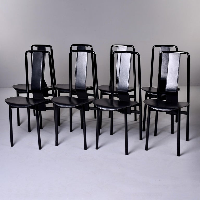 Circa 1979 set of 8 Irma dining chairs designed by Achille Castigliono for Zenotta. The chairs have black metal frames with a distinctive angled backrest and are upholstered in black leather. Sold and priced as a set of eight. Tagged by maker.