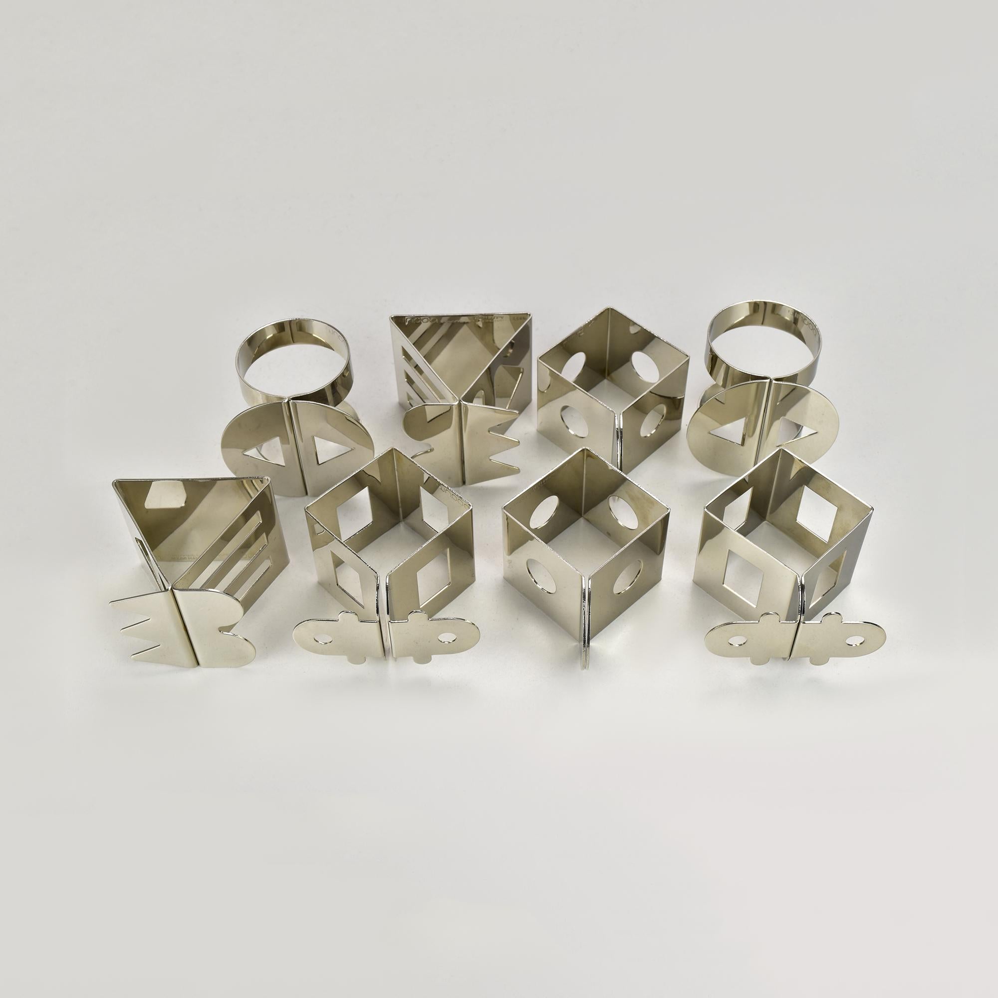 Striking set of 8 postmodern (two of each patten) napkin rings created for Bodum by Memphis-affiliated designers Nathalie Du Pasquier and Jumi Chan. These sculptural table accessories showcase geometric shapes, bold silhouettes, and playful