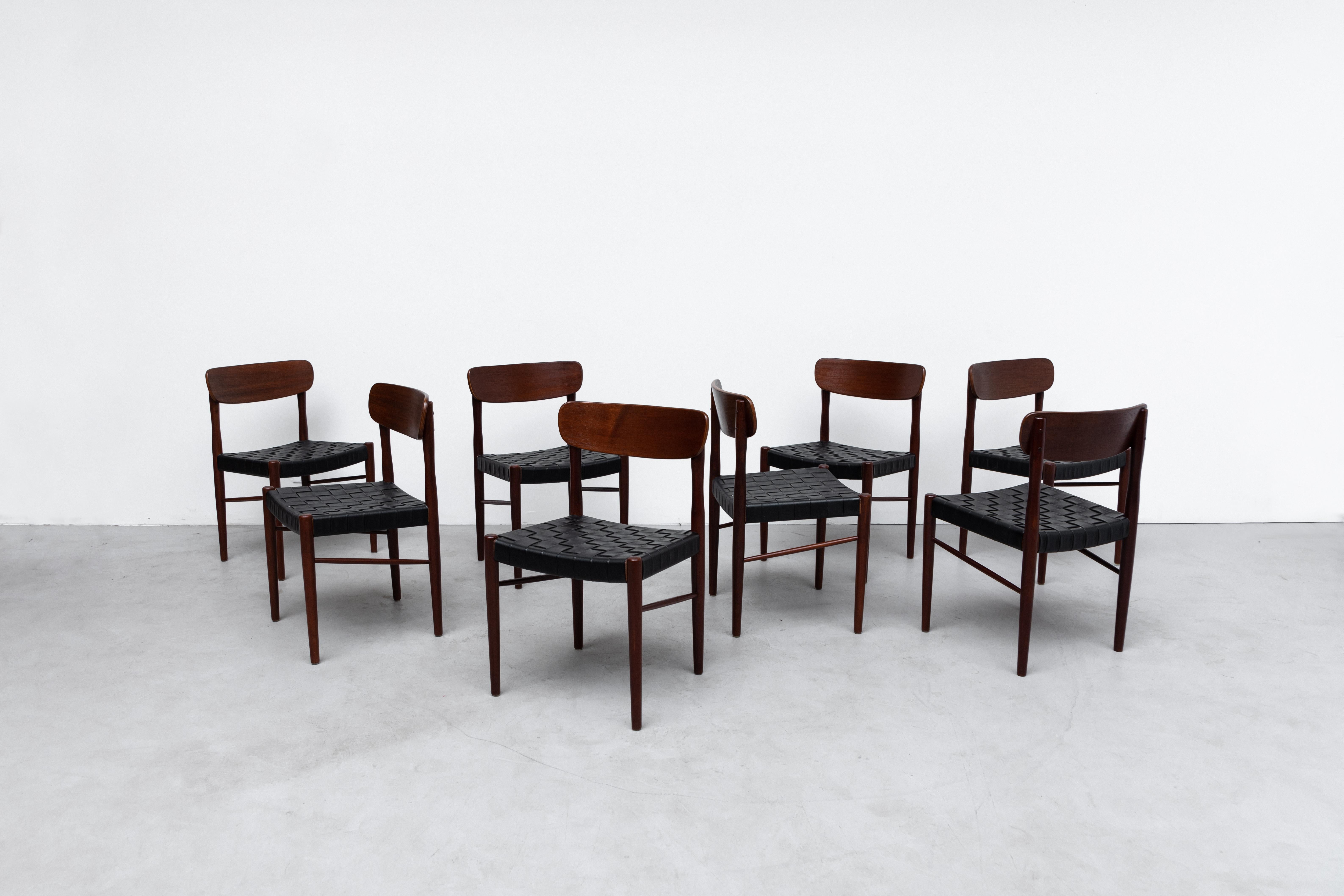 Gorgeous set of 8 Børge Mogensen style Danish dining chairs with black woven faux leather seating and lightly refinished teak frame. In good overall condition with some wear consistent with age and use. Set price.