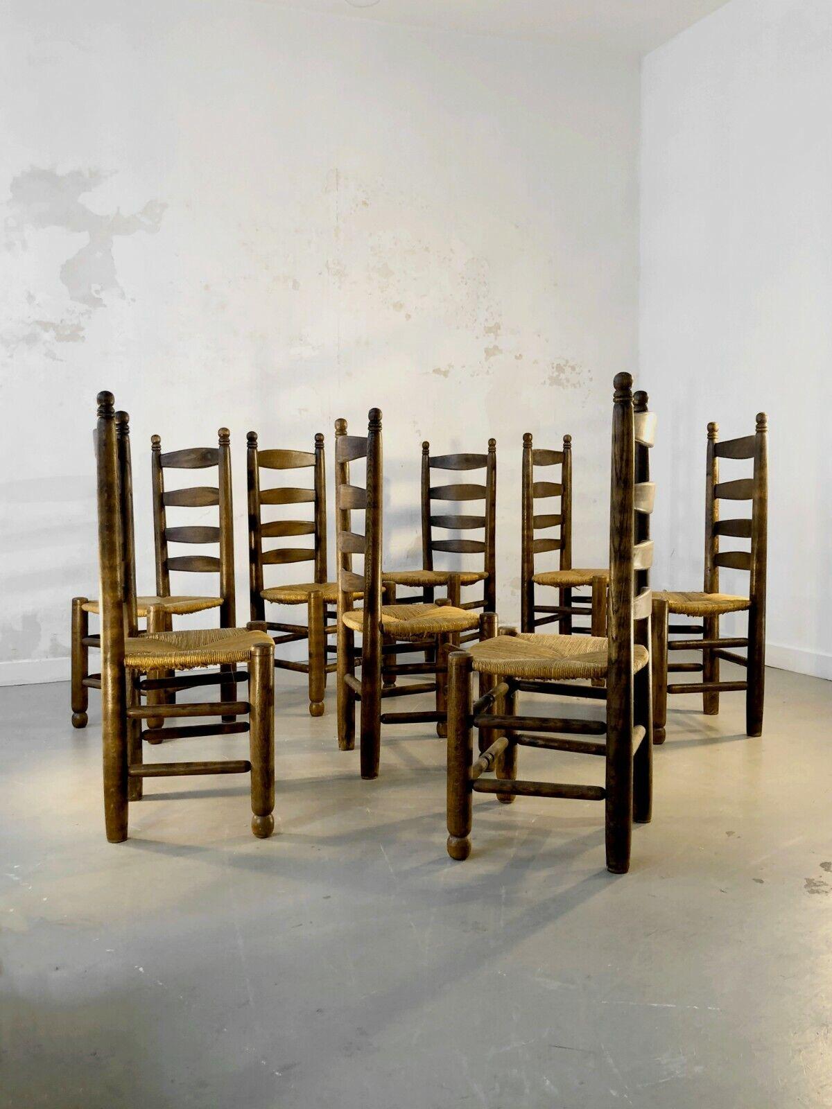 A set of 8 powerfull chairs in massive dark wood and bright straw seatings, by Charles Dudouyt, France 1950. The thick wood structures are giving the chairs a strong and solid feel, when their high lines are designing a mental space over the table