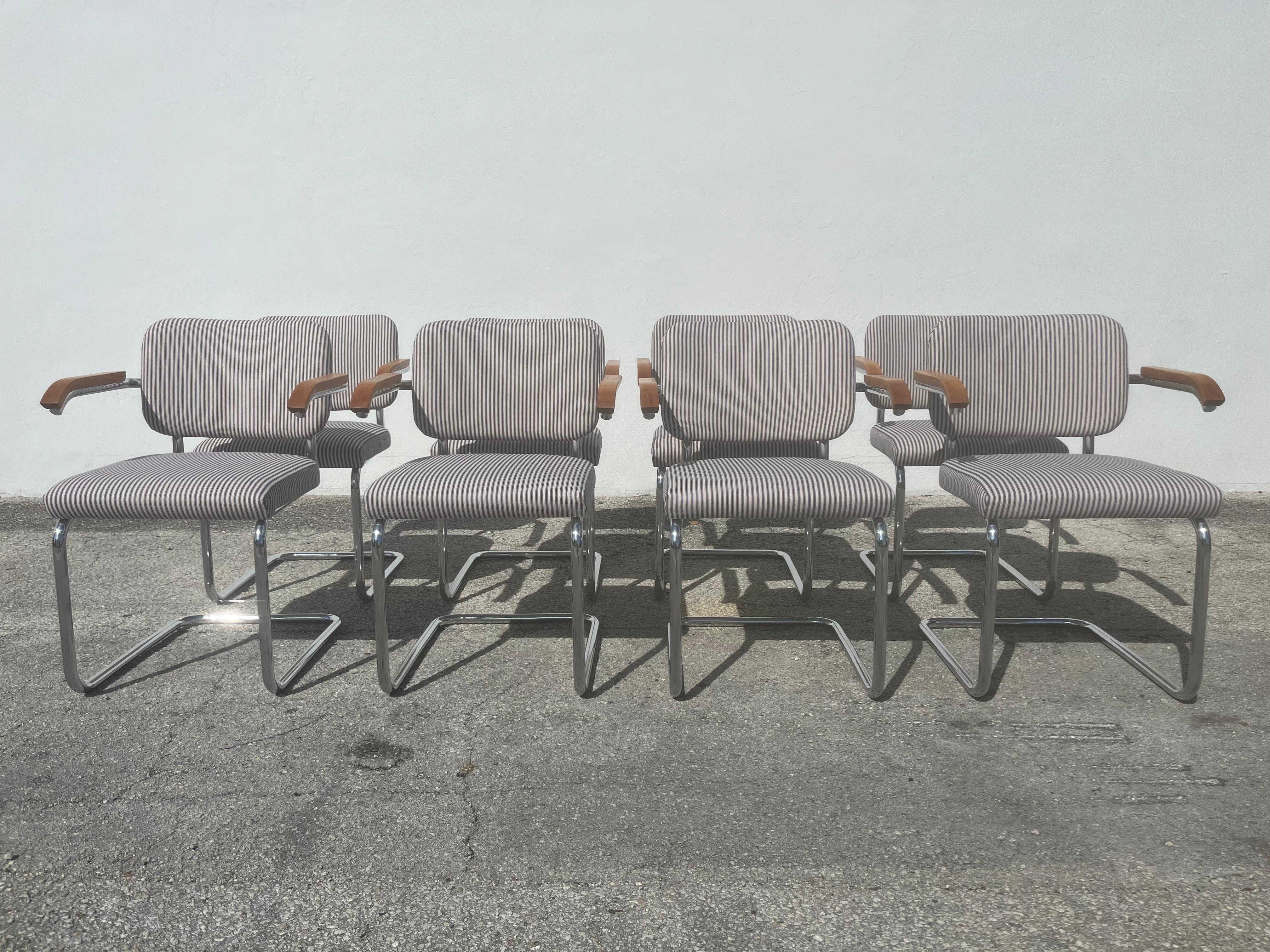 Set of 8 Cesca Upholstered Arm Chairs by Marcel Breuer for Knoll. The frame is made of one continuous chromed tubular steel pipe. Seats and backs have been professionally reupholstered in beige and black striped cotton fabric. Foam is new. Arms are