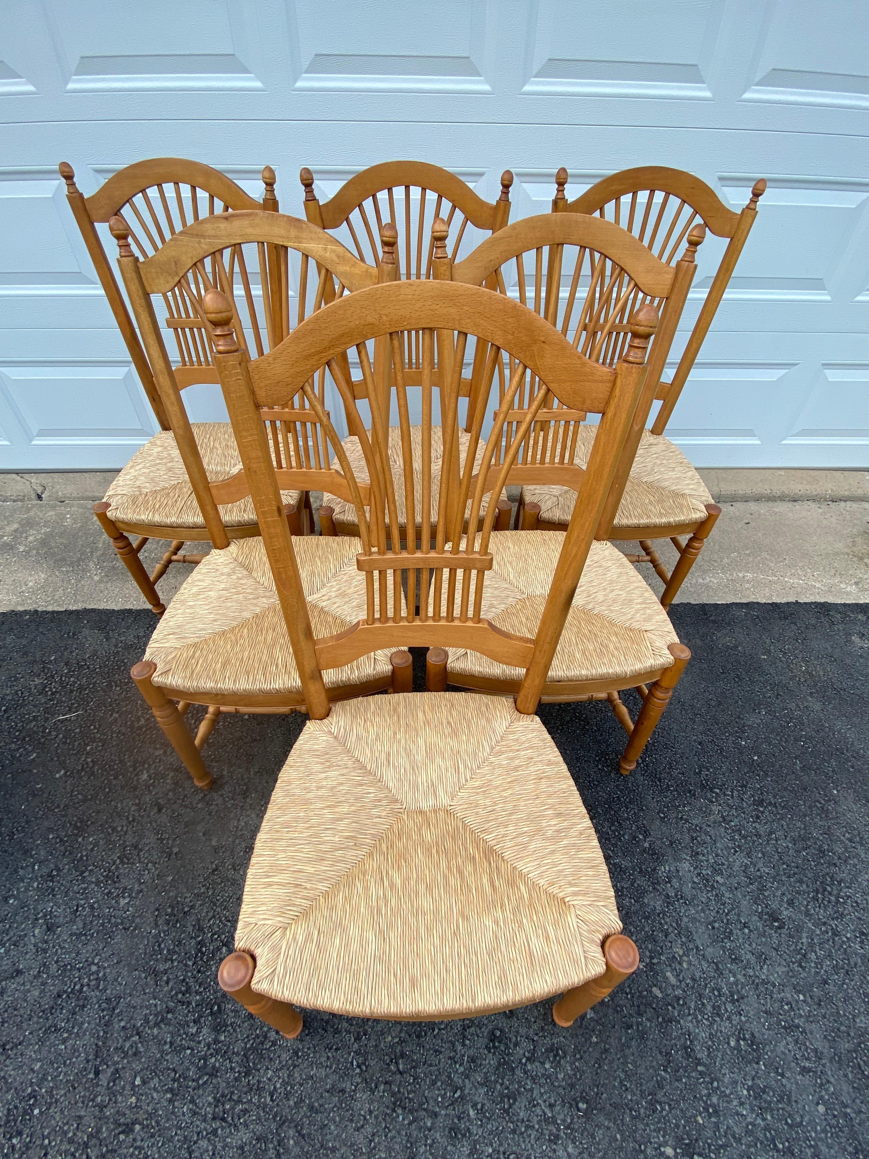 Classic beautiful set of 8 wheat sheaf motif dining chairs, either beech or cherry, with timeless rush seats in great shape. There are 2 arm chairs; 6 sides. 
 Dimensions above are for the 6 side chairs.
seat depth 17.25
Arm chairs are 1/4