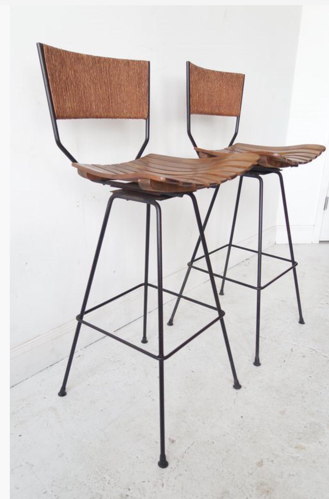 A set of four (4) clean-lined bar stools with wood slatted seat, rattan back and black metal base.  USA, circa 1950.

Priced at $737.50 per stool or $5,900 as a set of eight; contact us to specify a different quantity.

Dimebsions:
37