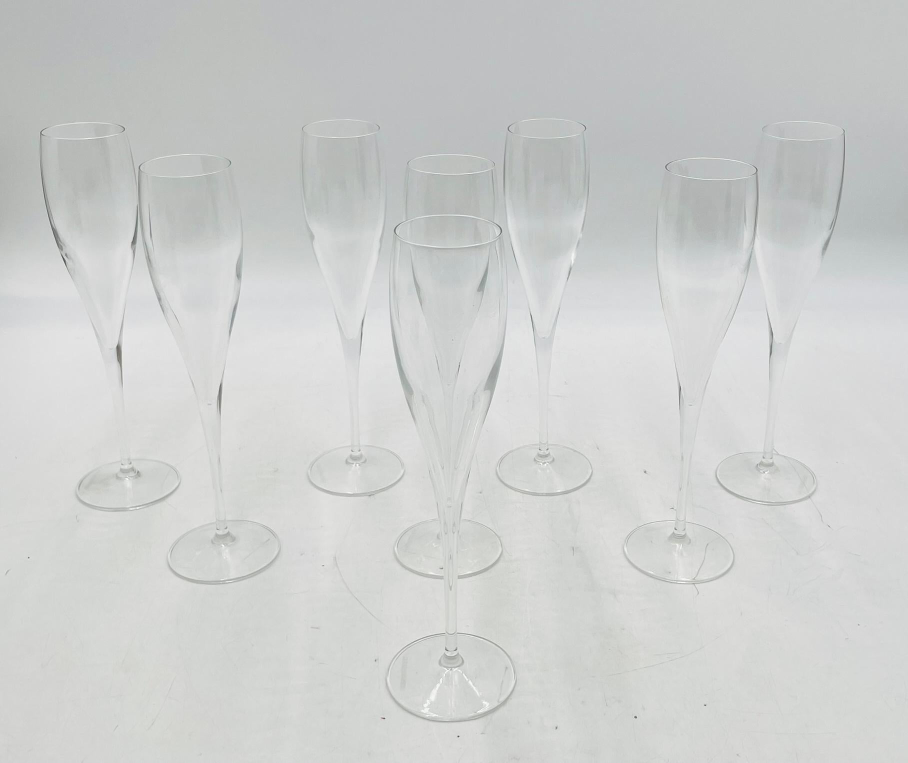 A sleek and elegant set of eight champagne flutes by iconic French maker Le Creuset, known globally for their dedication to craftsmanship and timeless design. These glasses are made of clear crystal and feature an elongated, gently tapering bowl