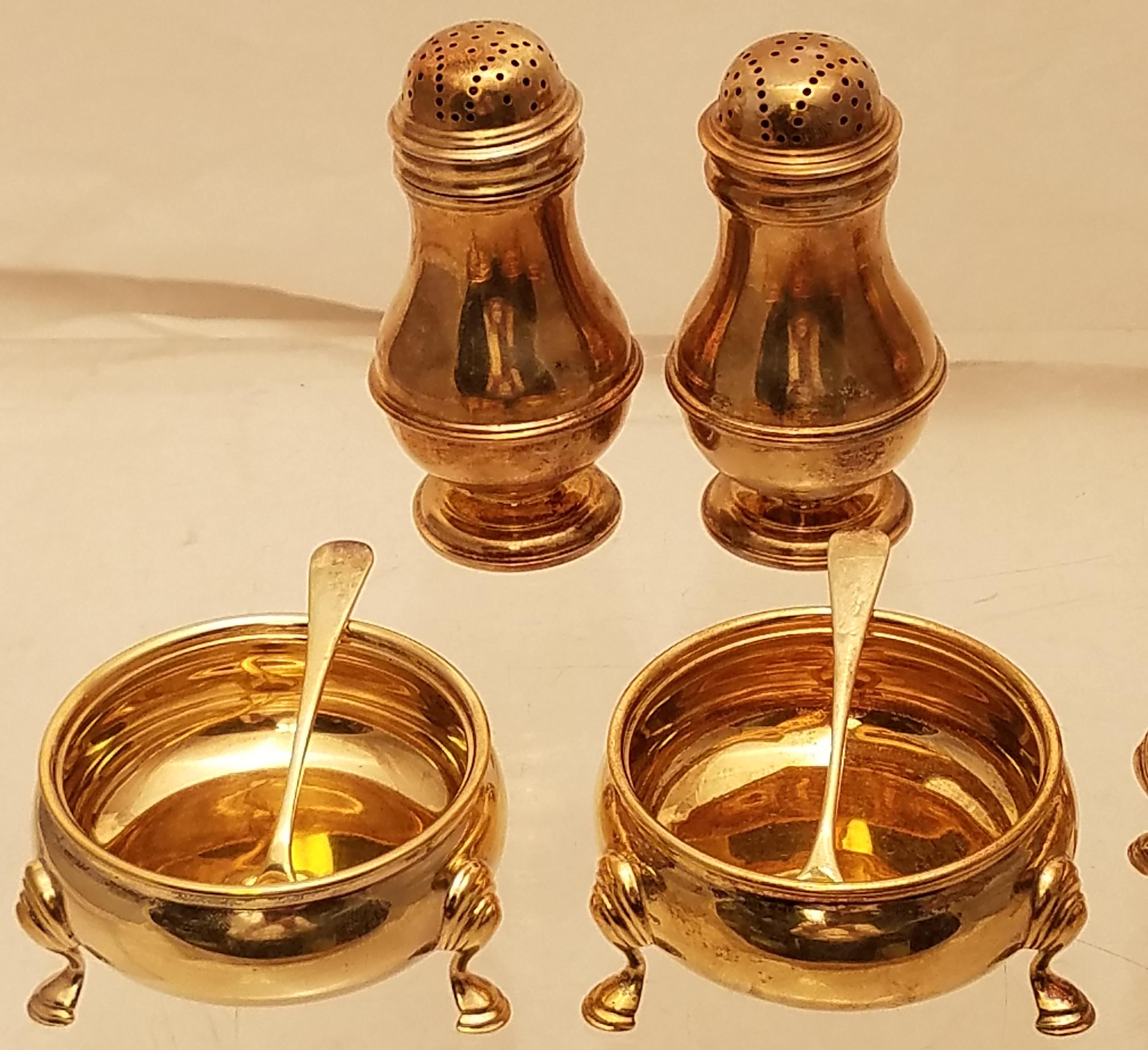 Fine gilt English silver set of 4 salt and pepper condiments. It consists of 4 salt and pepper shakers, 4 open footed salt dishes, and 2 salt spoons. It is made by Richard Comyns, a London-based silversmith, and dates from 1927, and is in Georgian