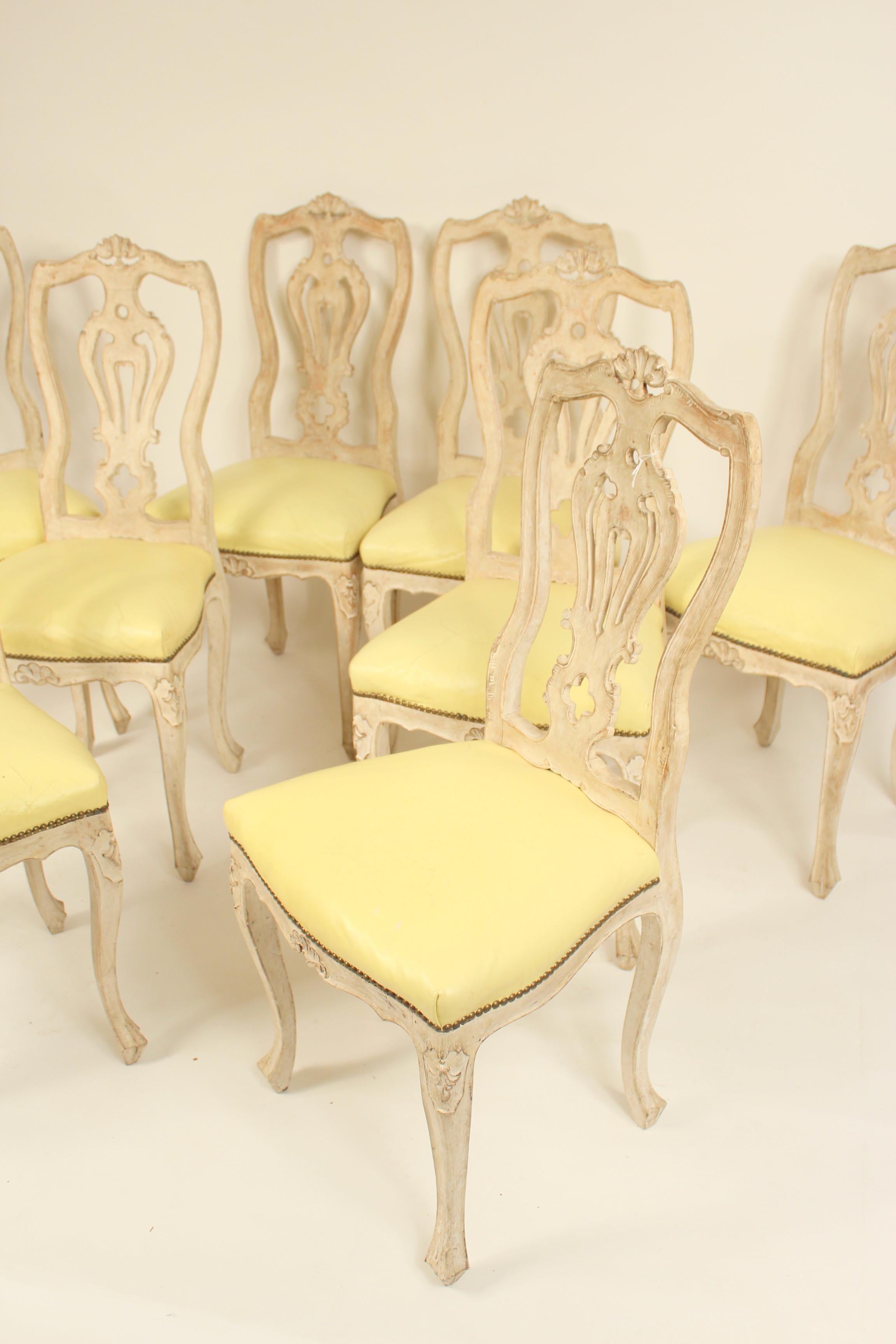 Set of 8 continental painted Louis XV style dining room chairs with light yellow vinyl seats, mid-20th century.