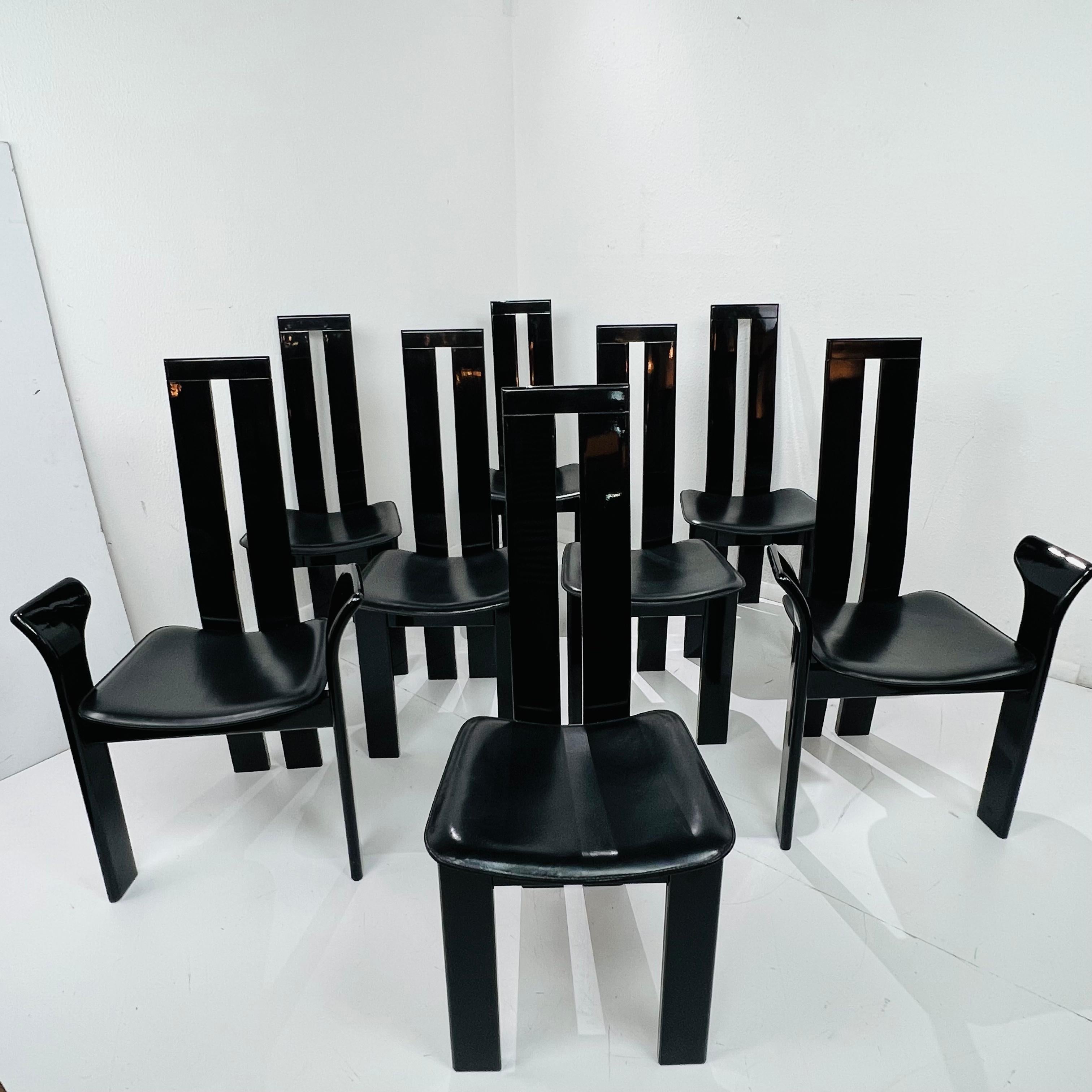 Schicker Satz postmoderner Esszimmerstühle, entworfen von Pietro Costantini in San Vito al Torre, Italien. Die ikonischen Stühle zeichnen sich durch skulpturale, schwarz lackierte Gestelle mit anschmiegsamen Sitzpolstern aus schwarzem Leder aus. Das