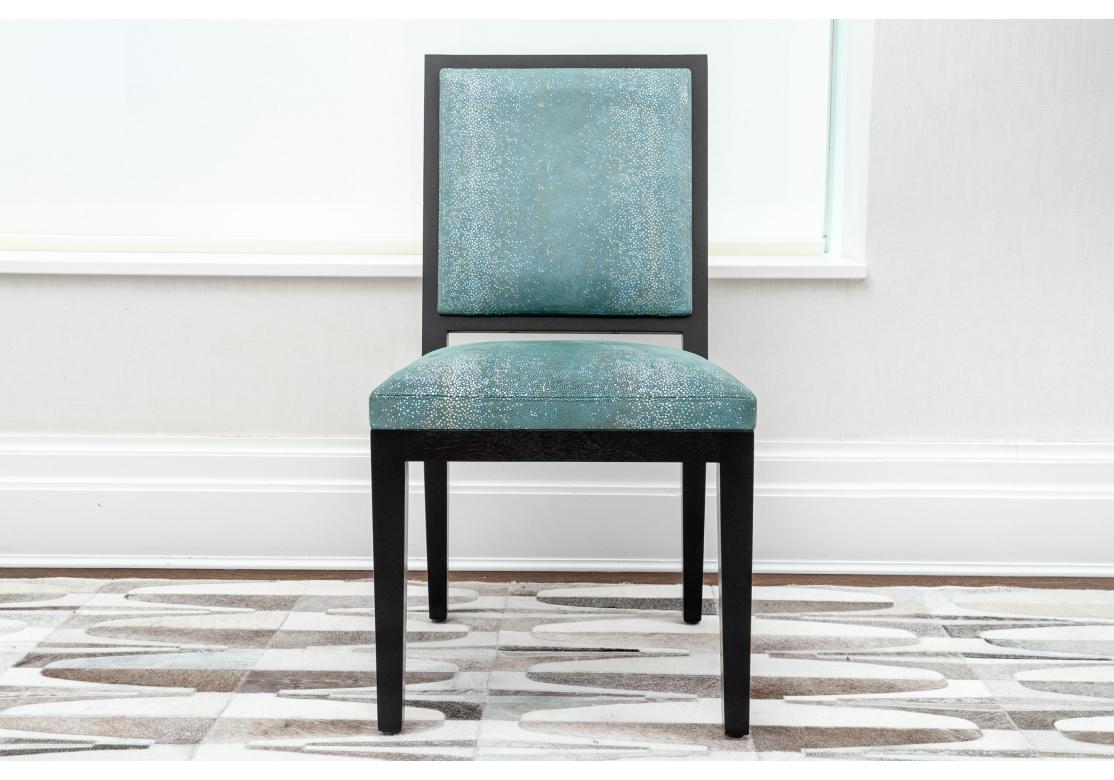 Set of 8 custom upholstered dining chairs by Christian Liaigre with black frames and blue/silver/white shimmering fabric in a micro-mosaic pattern. The backrests with just the hint of sloped back in a nearly square form. The chairs resting on