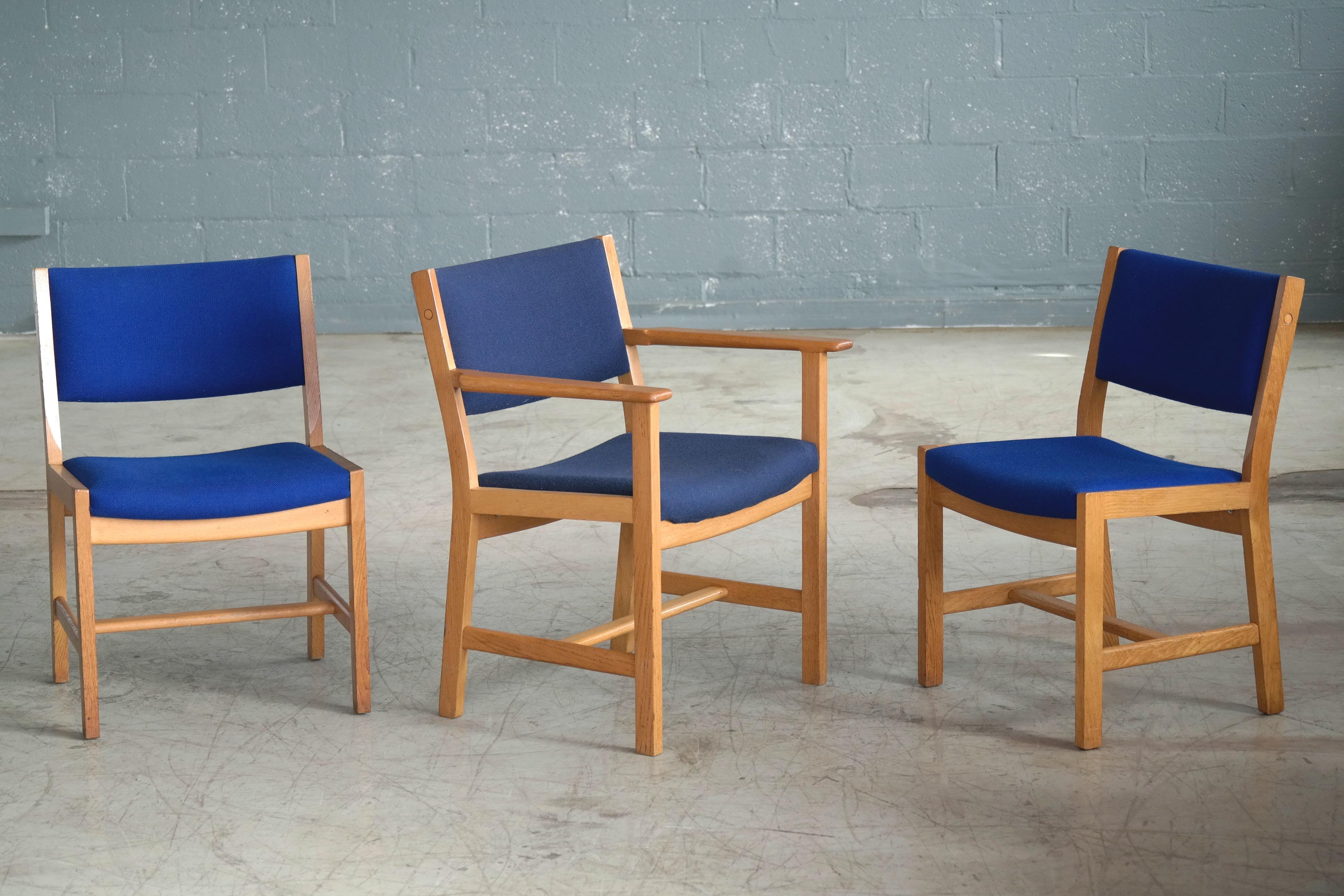 We love the angular modern clean lines of this set of Hans Wegner designed dining chairs produced by GETAMA of Denmark in the early 1970s. Manufactured from solid white oak and covered in blue wool fabric by Kvadrat. The set has seven side chairs