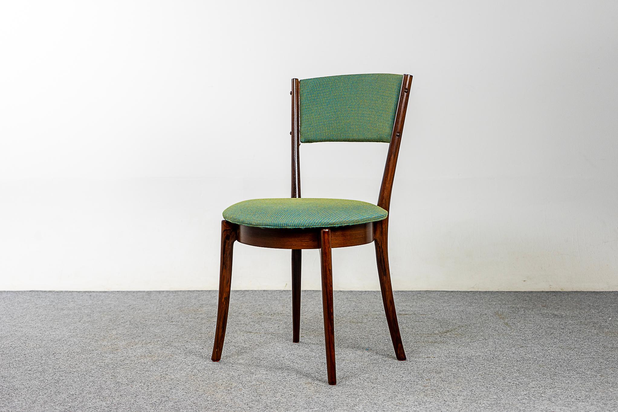 Rosewood Danish mid-century dining chairs, circa 1960's. Beautifully curved tapered backrests and unique circular seat. Gentle, graceful sculptural lines in the splayed legs. Stunning new upholstery with a subtle weave pattern to create balance