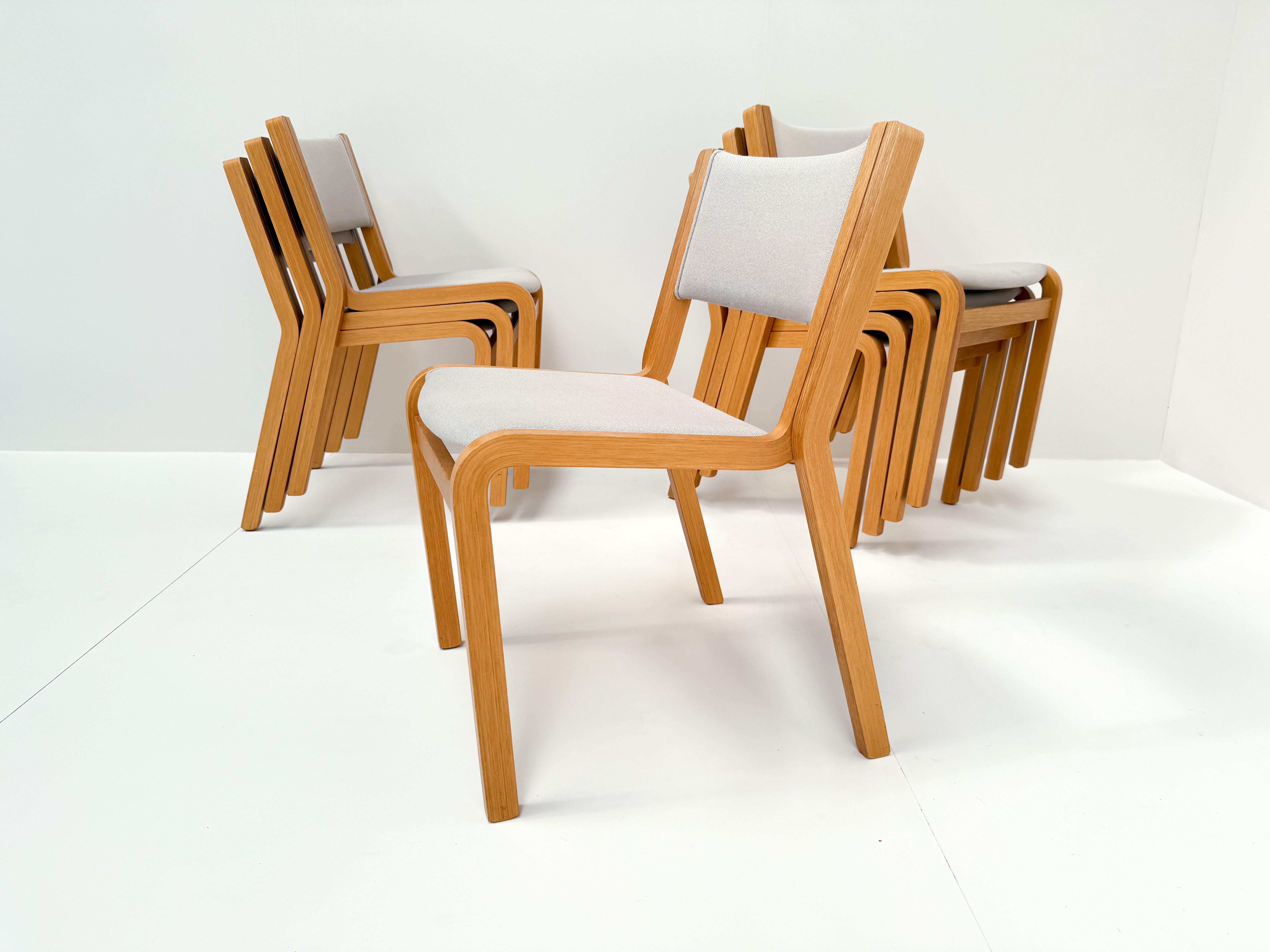 Raro y completo conjunto de ocho sillas modernas danesas apilables diseñadas en los años 70 por Rud Thygesen y Johnny Sørensen para Magnus Olesen. Estas icónicas sillas presentan una escultural estructura de madera de haya curvada y una silueta